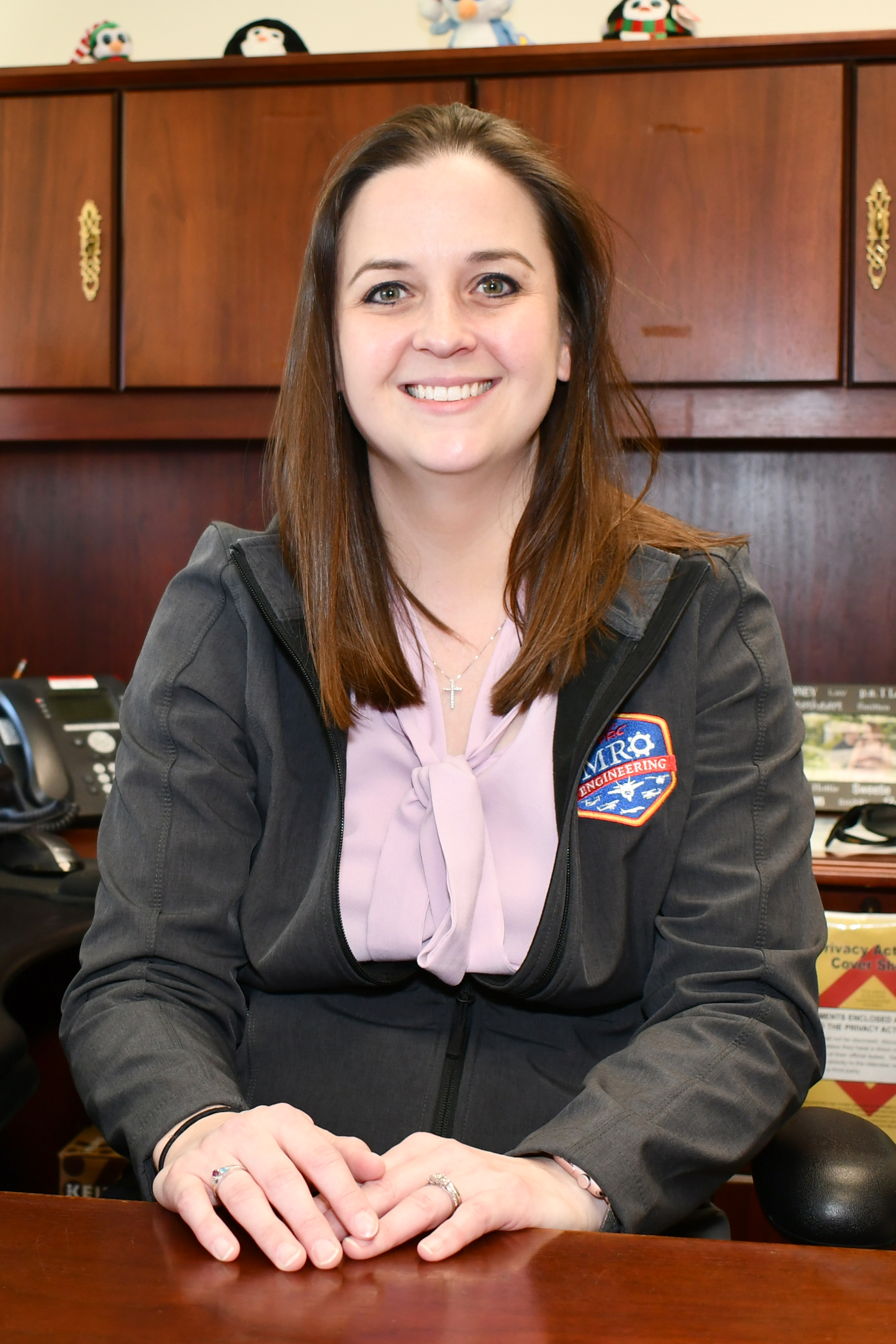 FRC East mentor poses for portrait behind desk