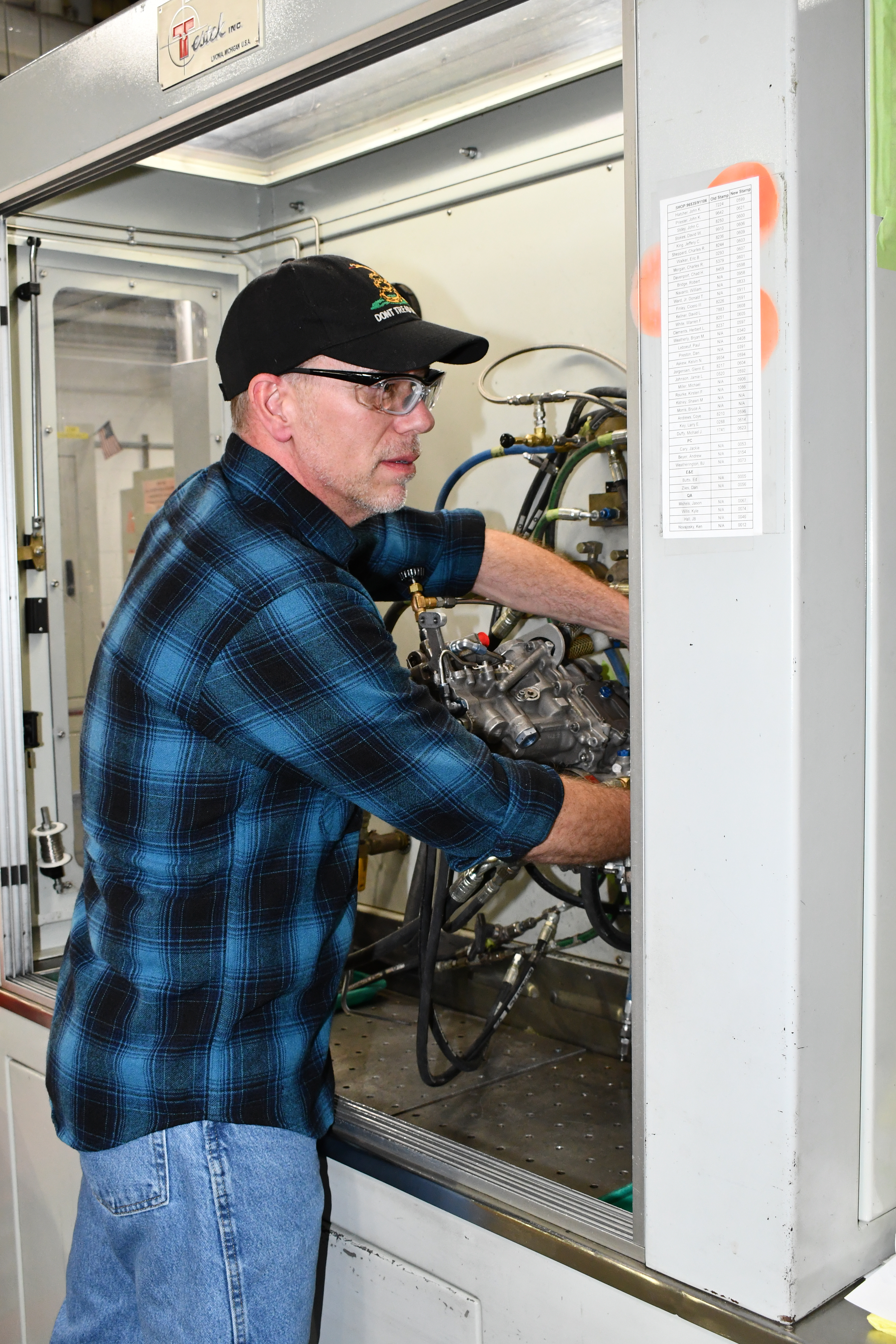 Aircraft maintainer connects fuel control unit to test stand for evaluation