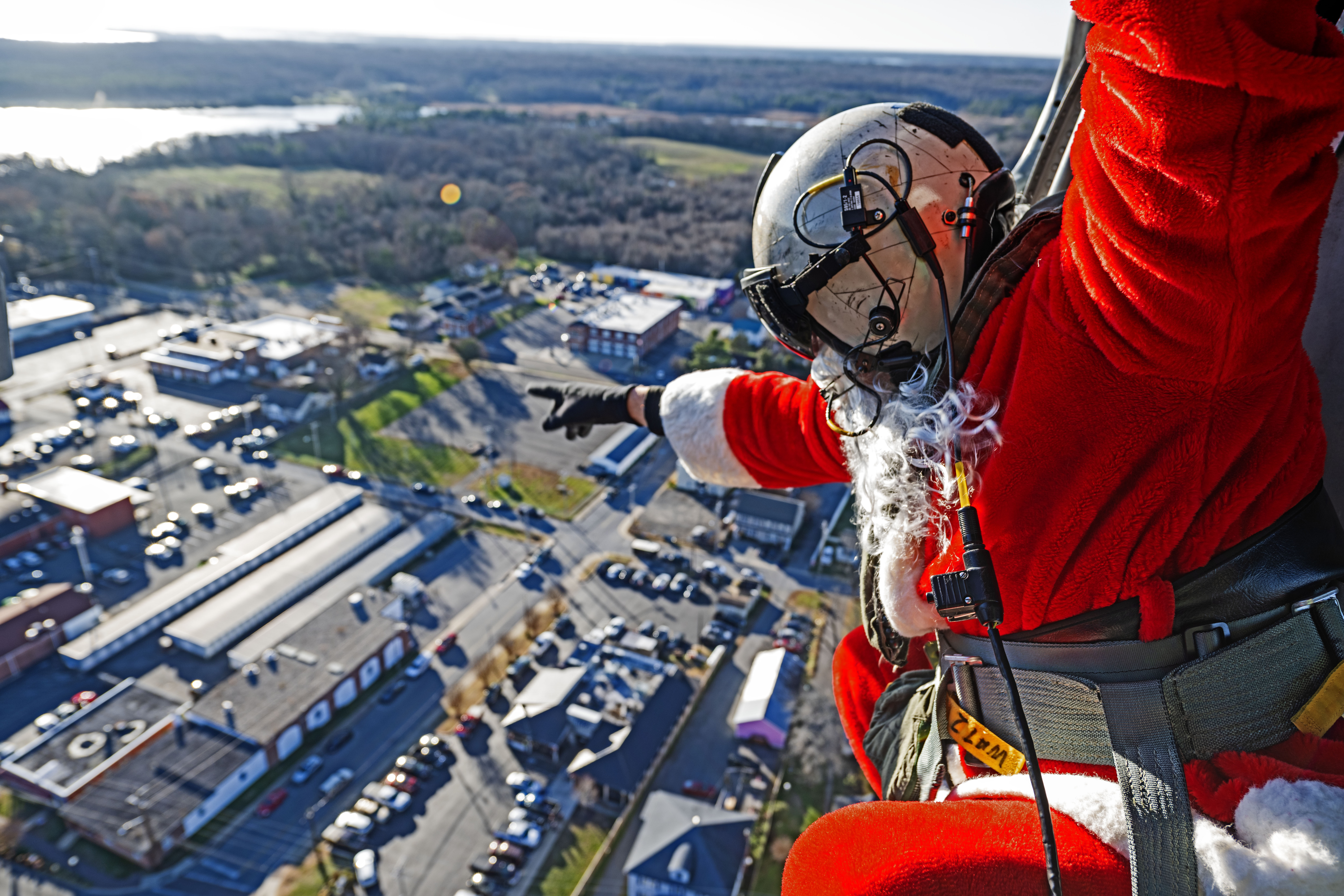 Santa waves to residents below from the skies of Southern Maryland aboard an in-flight MH-60S Seahawk helicopter.