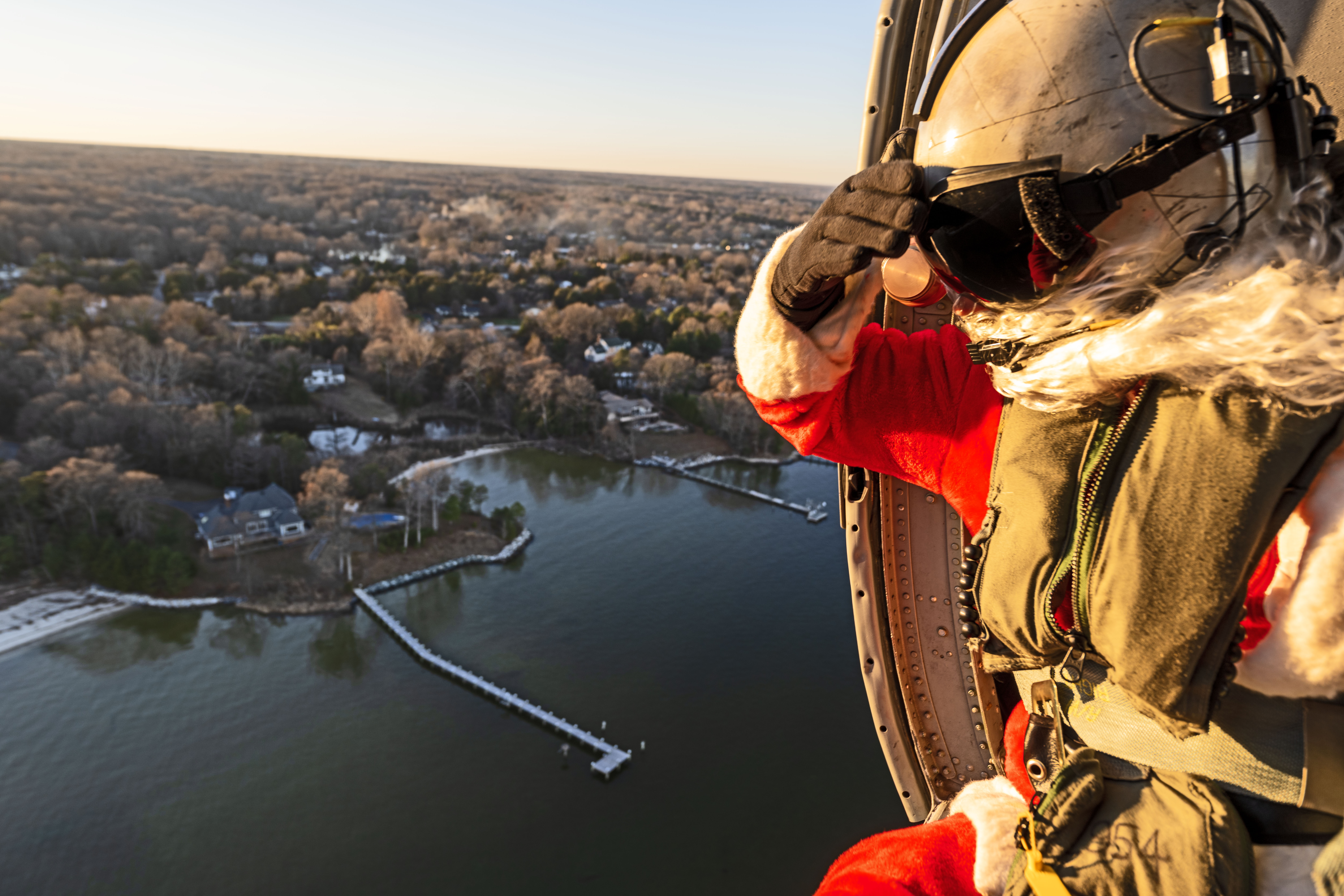 Adm. Santa Claus surveils neighborhoods lining the Patuxent River while flying onboard a U.S. Navy MH-60 Knighthawk helicopter.