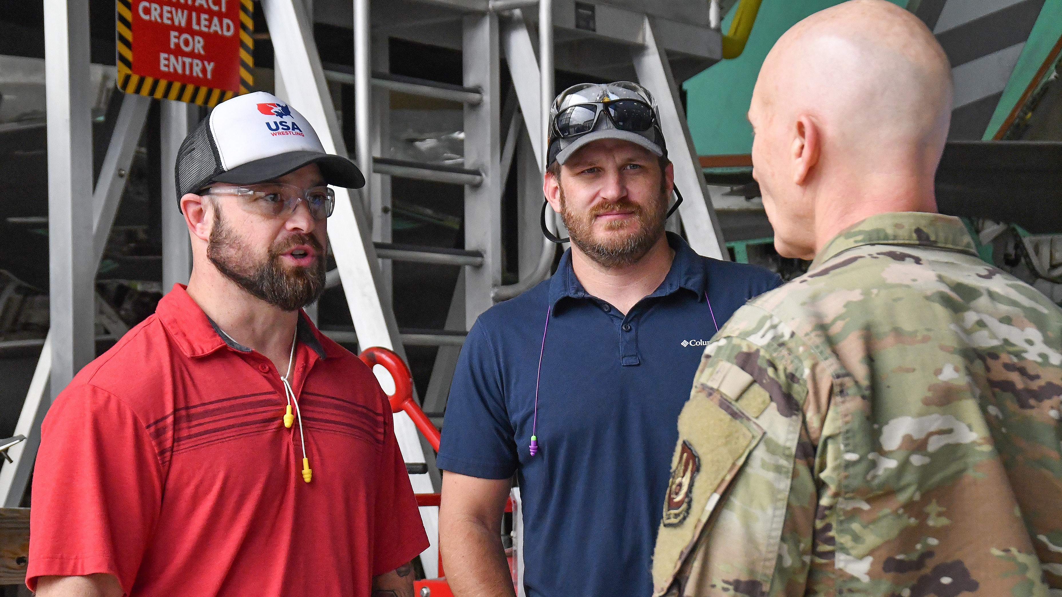 Air Force major general talks to two civilian aircraft maintainers
