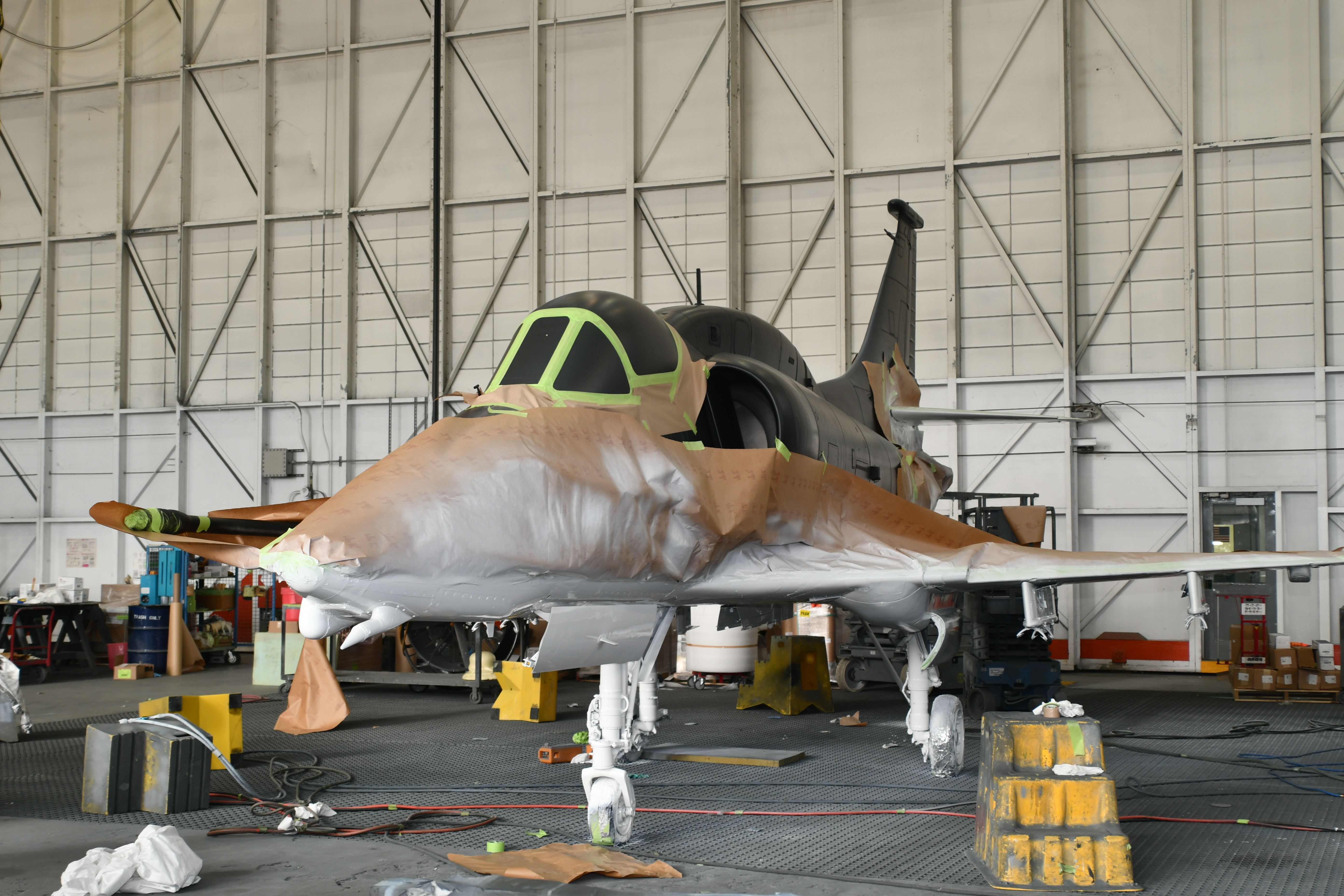 Aircraft with brown paper taped to it and white paint on bottom half