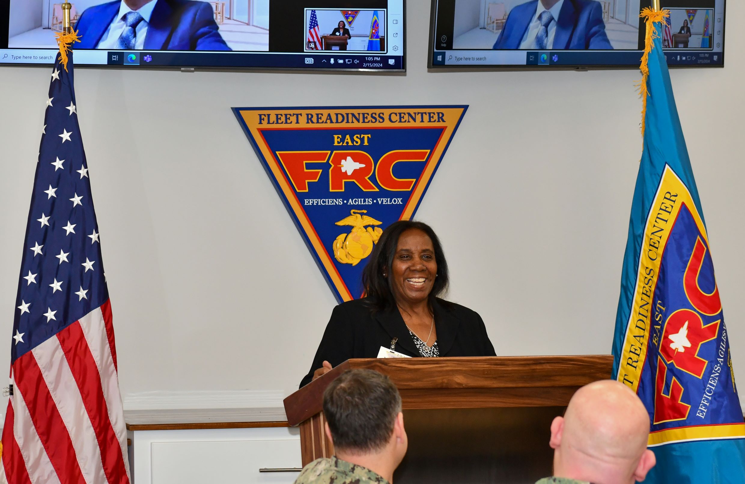 woman smiling while standing behind podium 