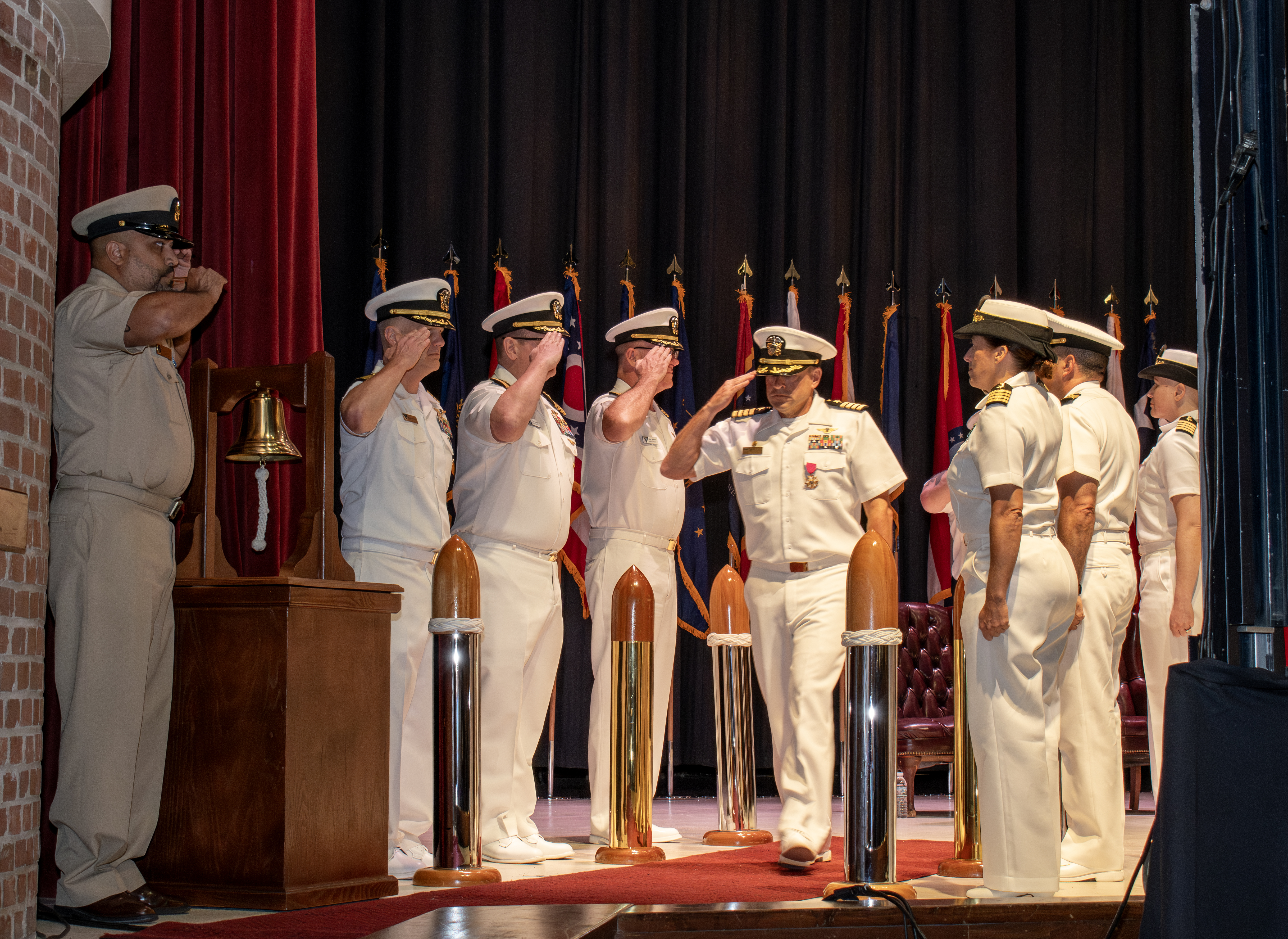 Sailors stand saluting 