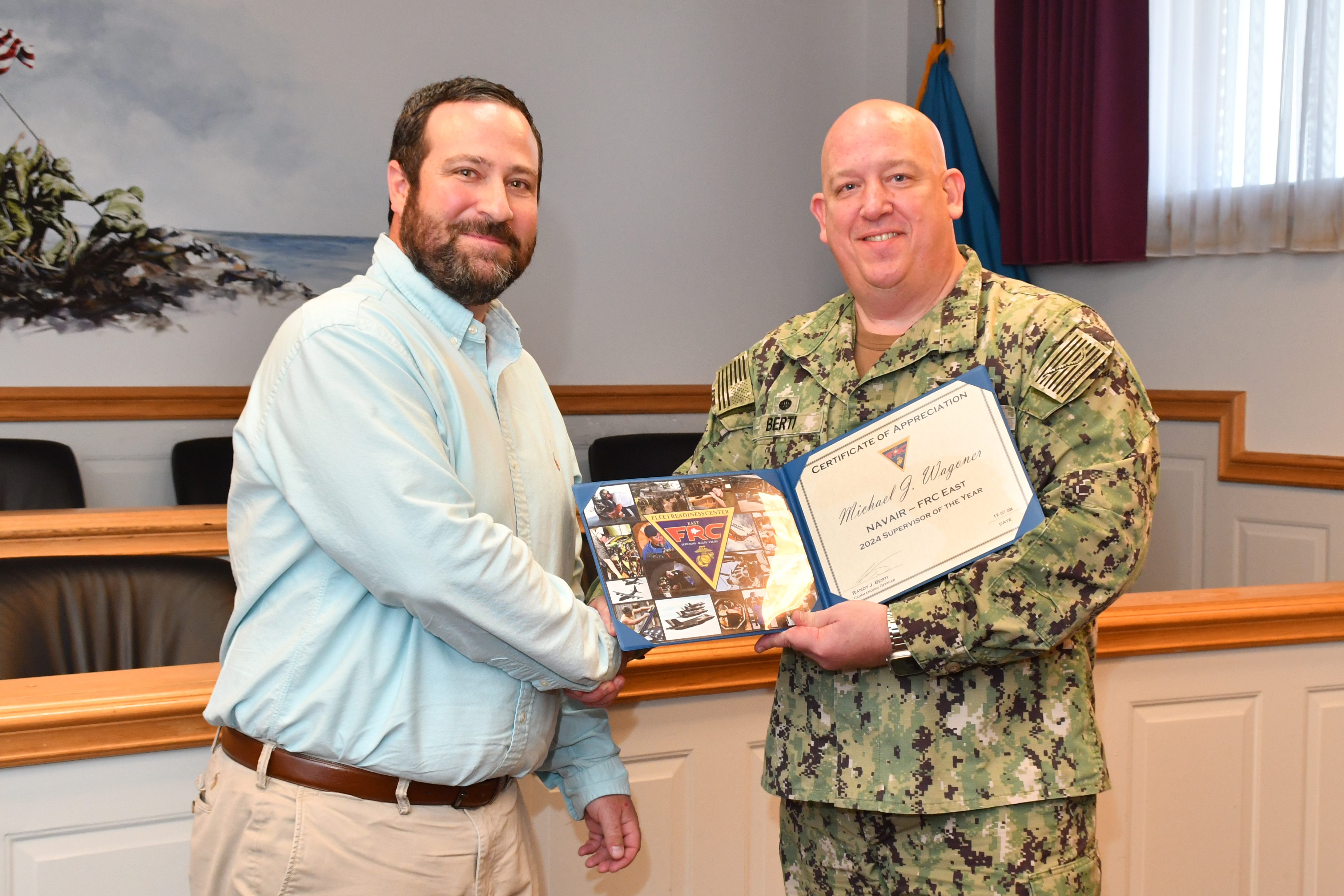 Man in military uniform stands with man in blue shirt 
