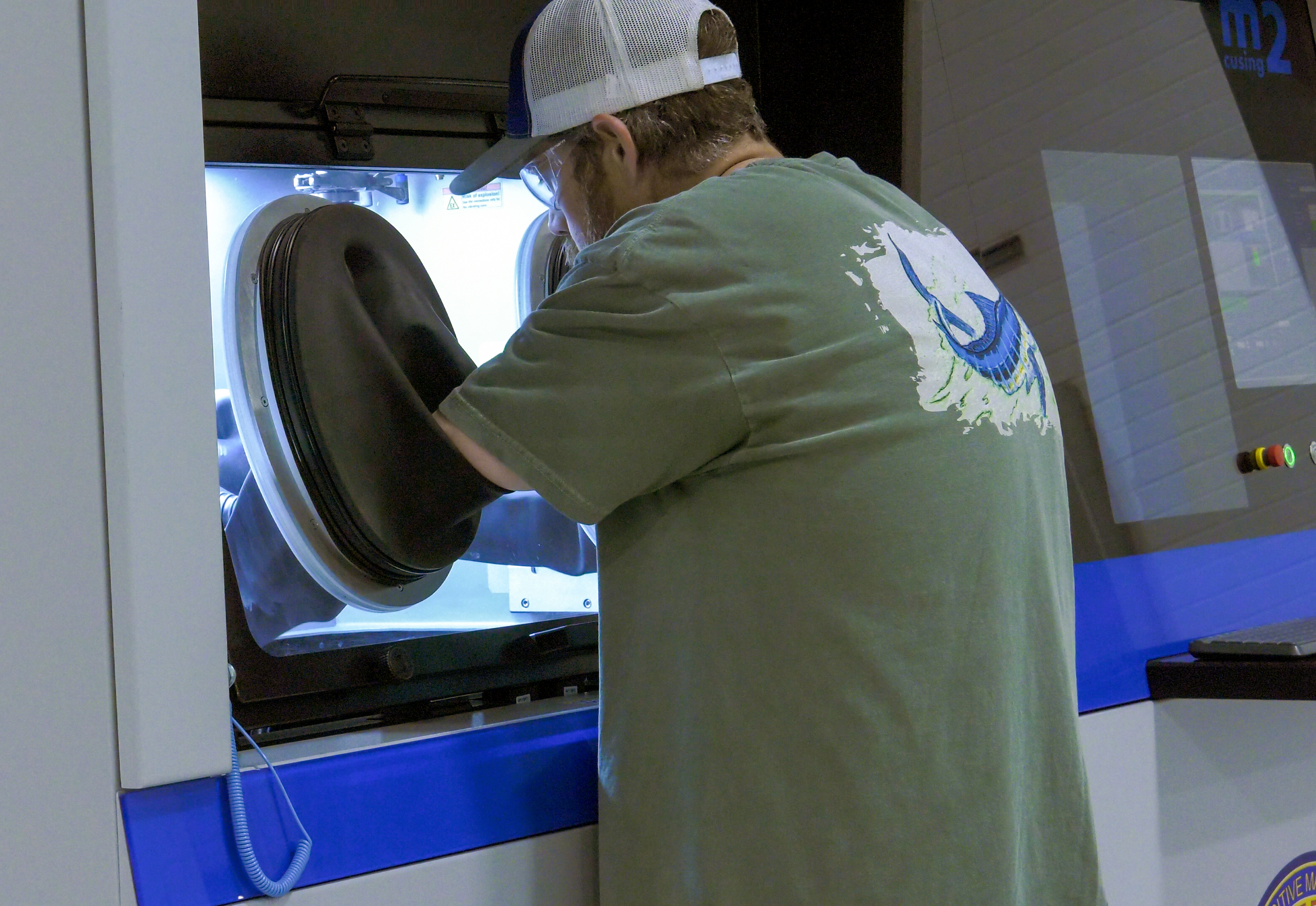 Man in green shirt uses machine