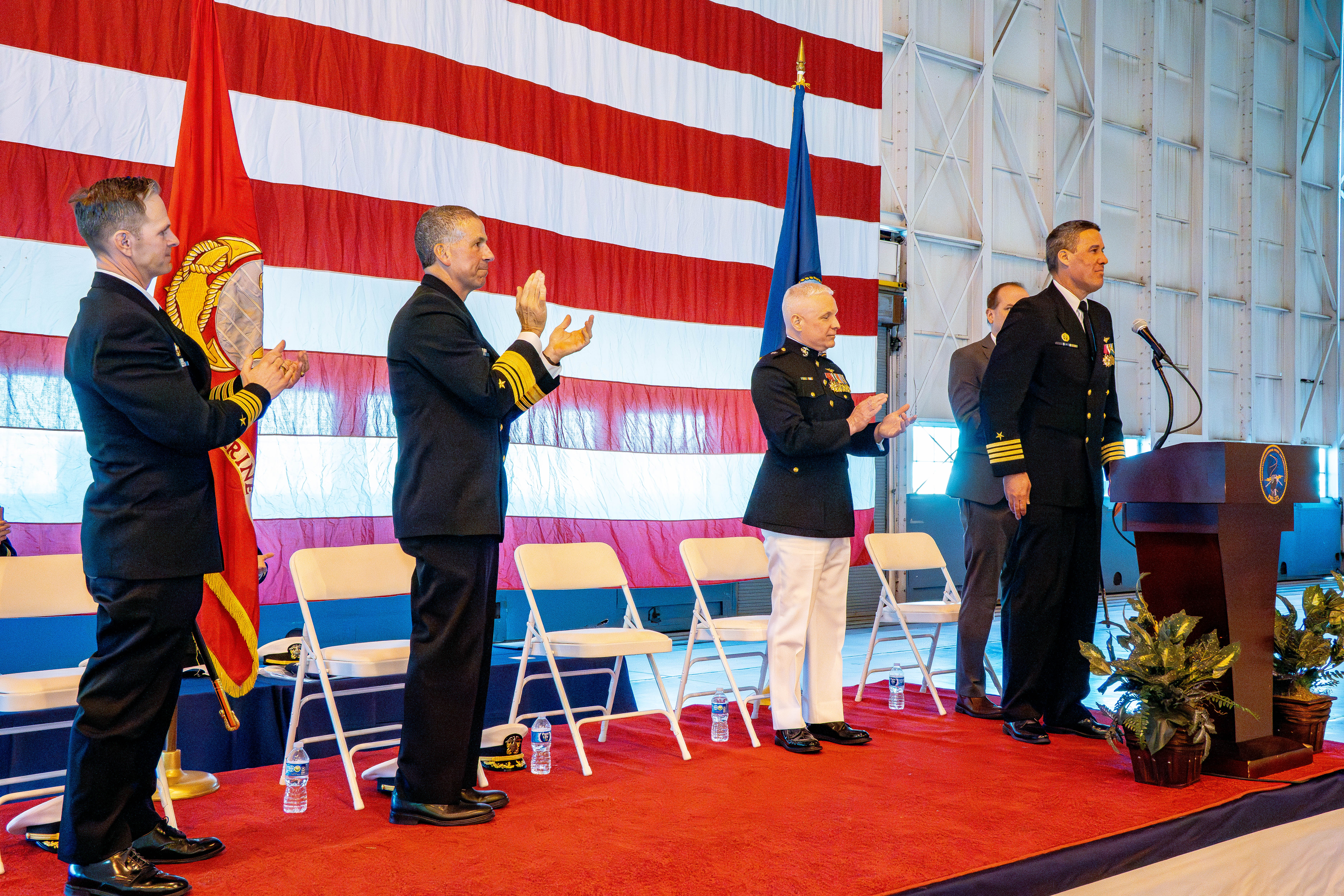 Sailors standing and clapping on a stage