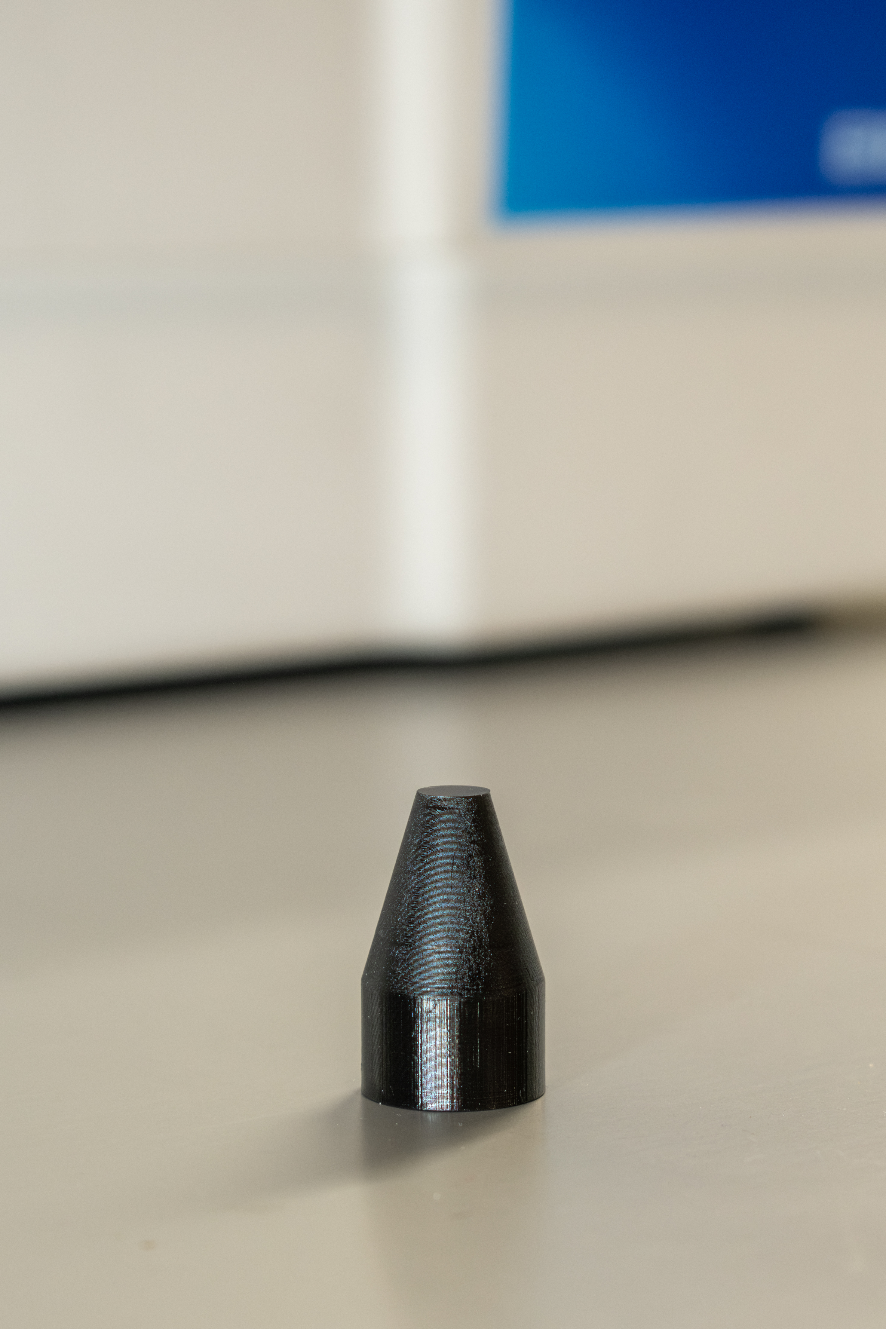 Close-up image of a small, black polymer cone that was 3D printed as a tool for F-35 Lightning II maintenance 
