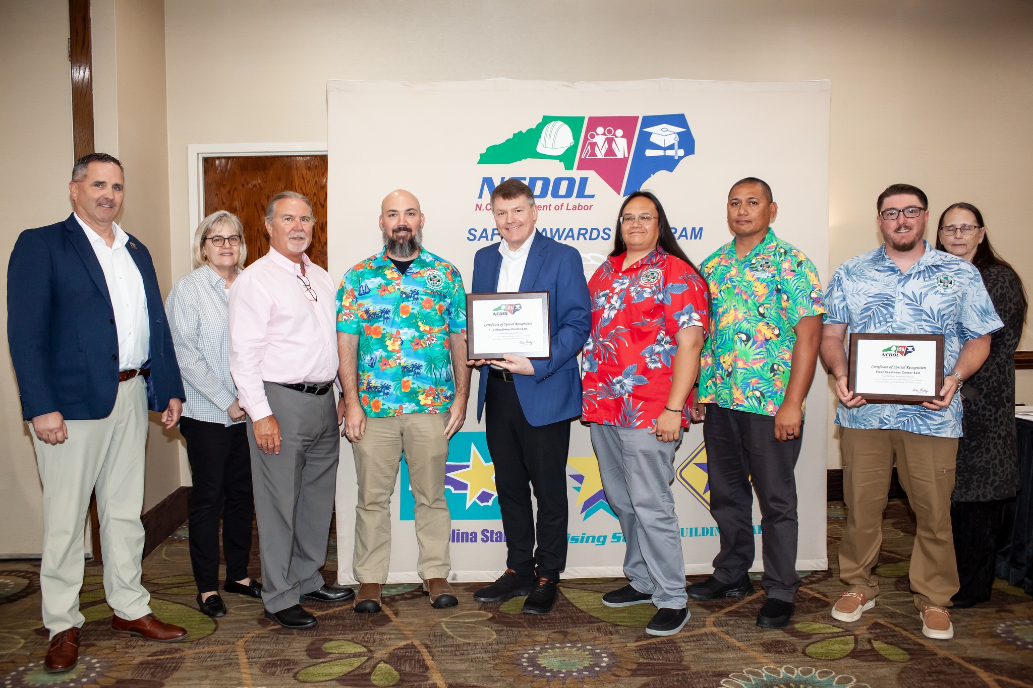 Group of people posing for photo, holding award certificates