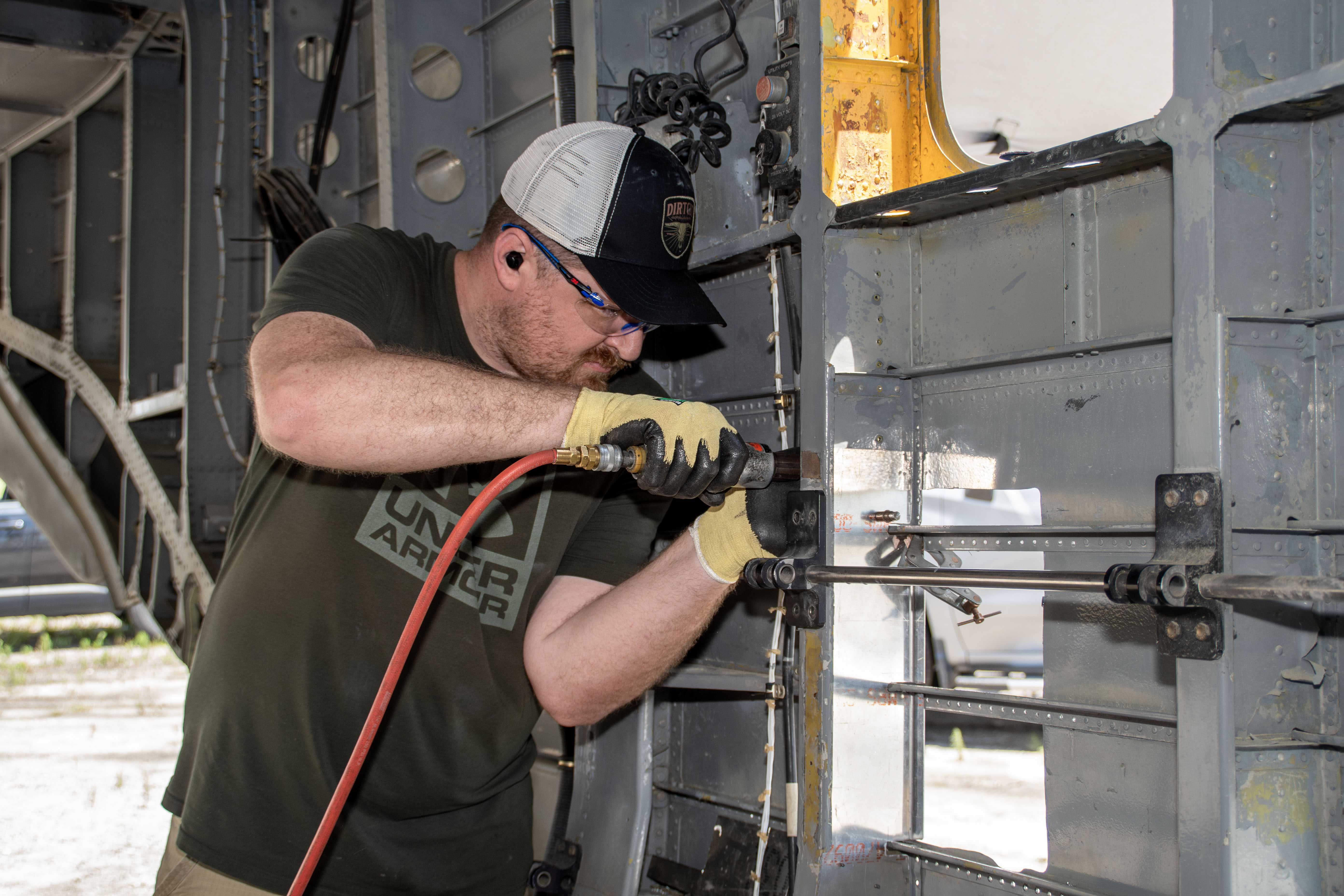 Man using tool to drill inside wall of an aircraft
