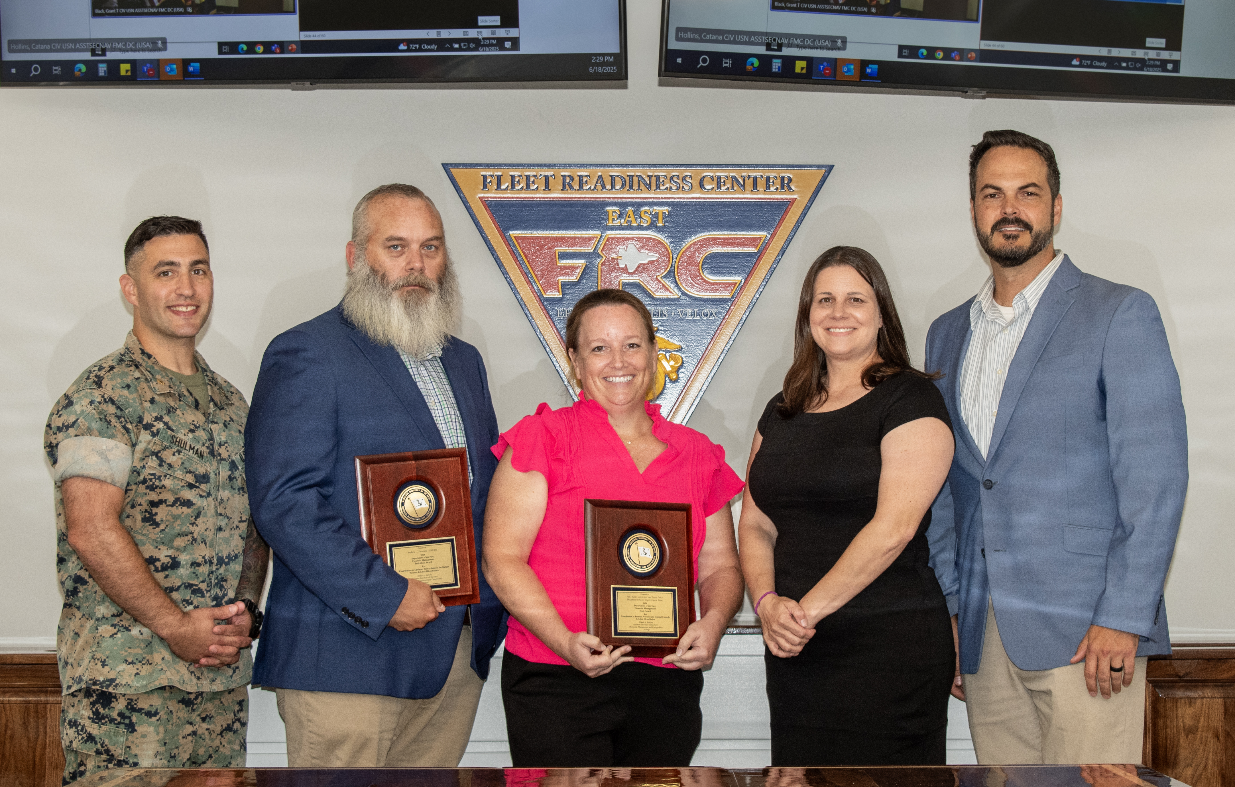 Group of five pose for photo with award plaques 