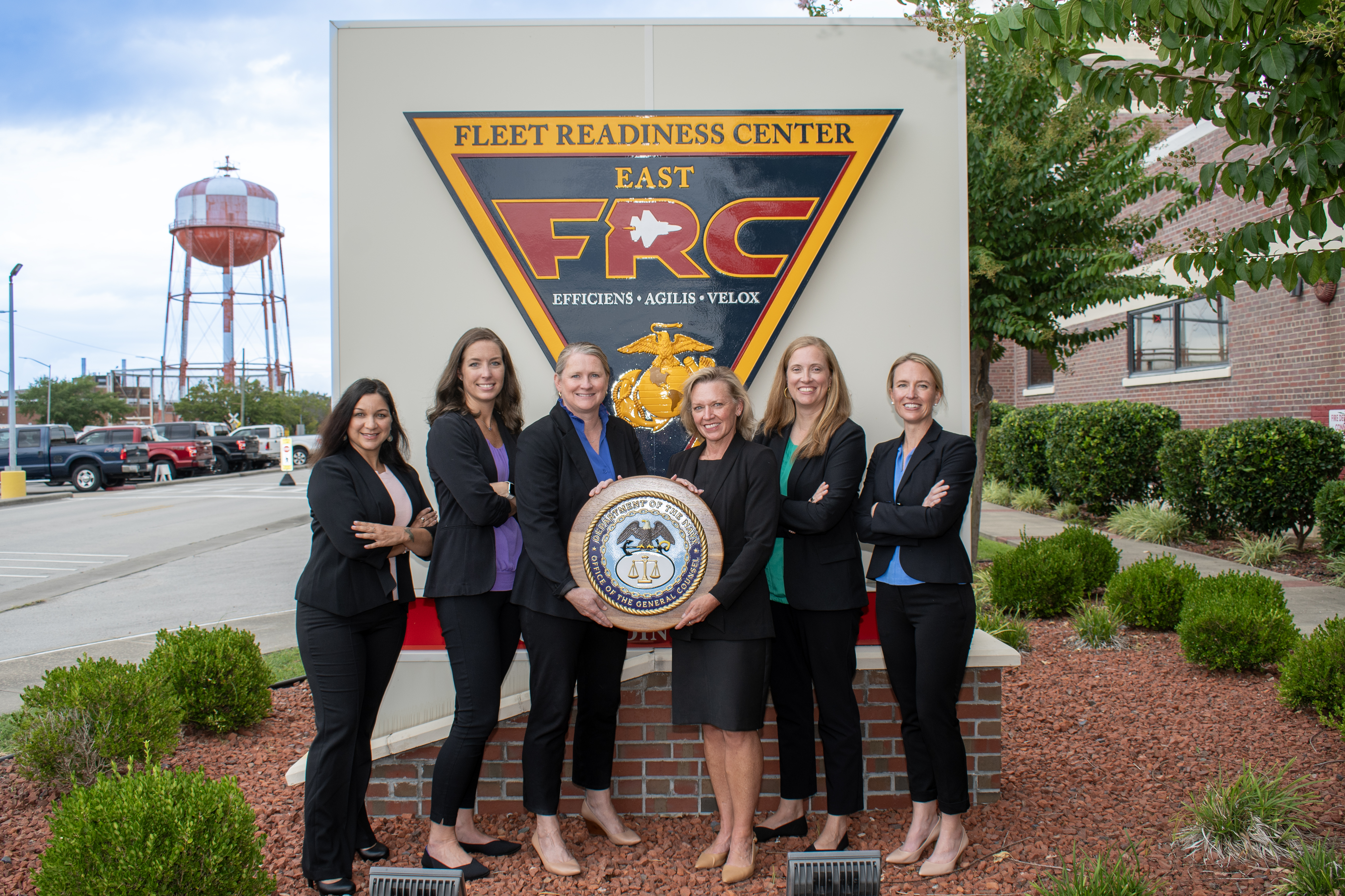 Group of professionally dressed staff pose for group photo
