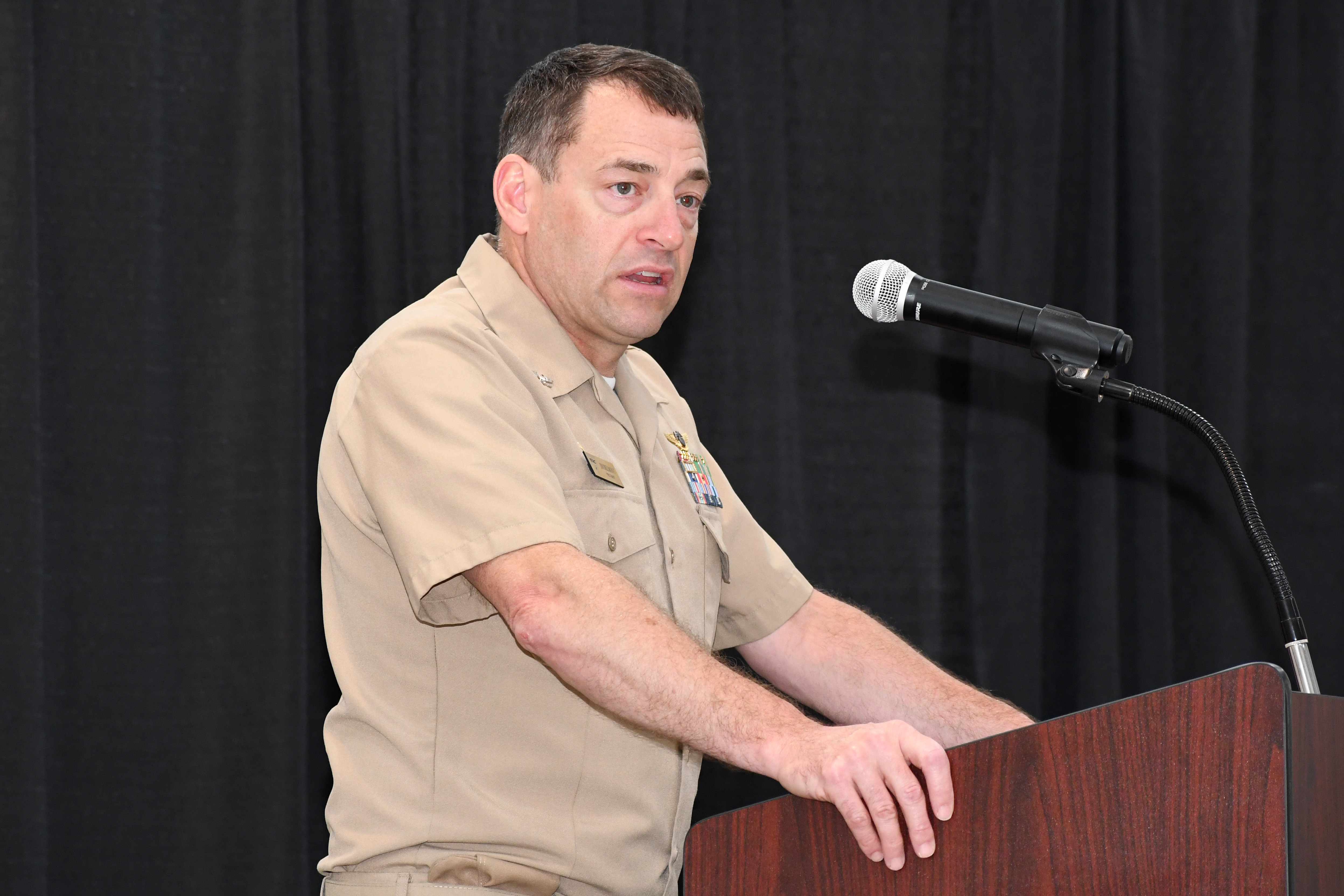 Man speaks from behind lectern