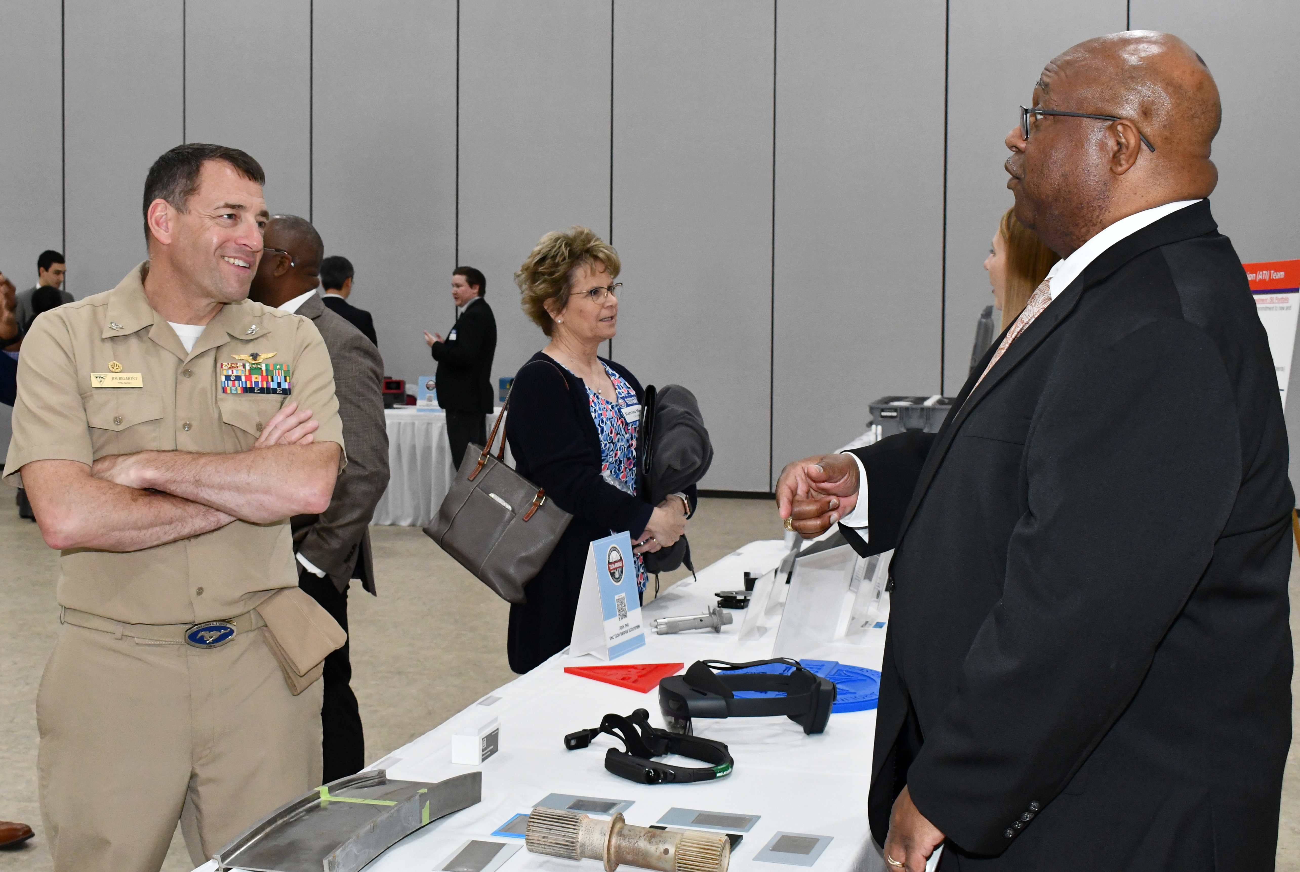 Two men speak across expo table
