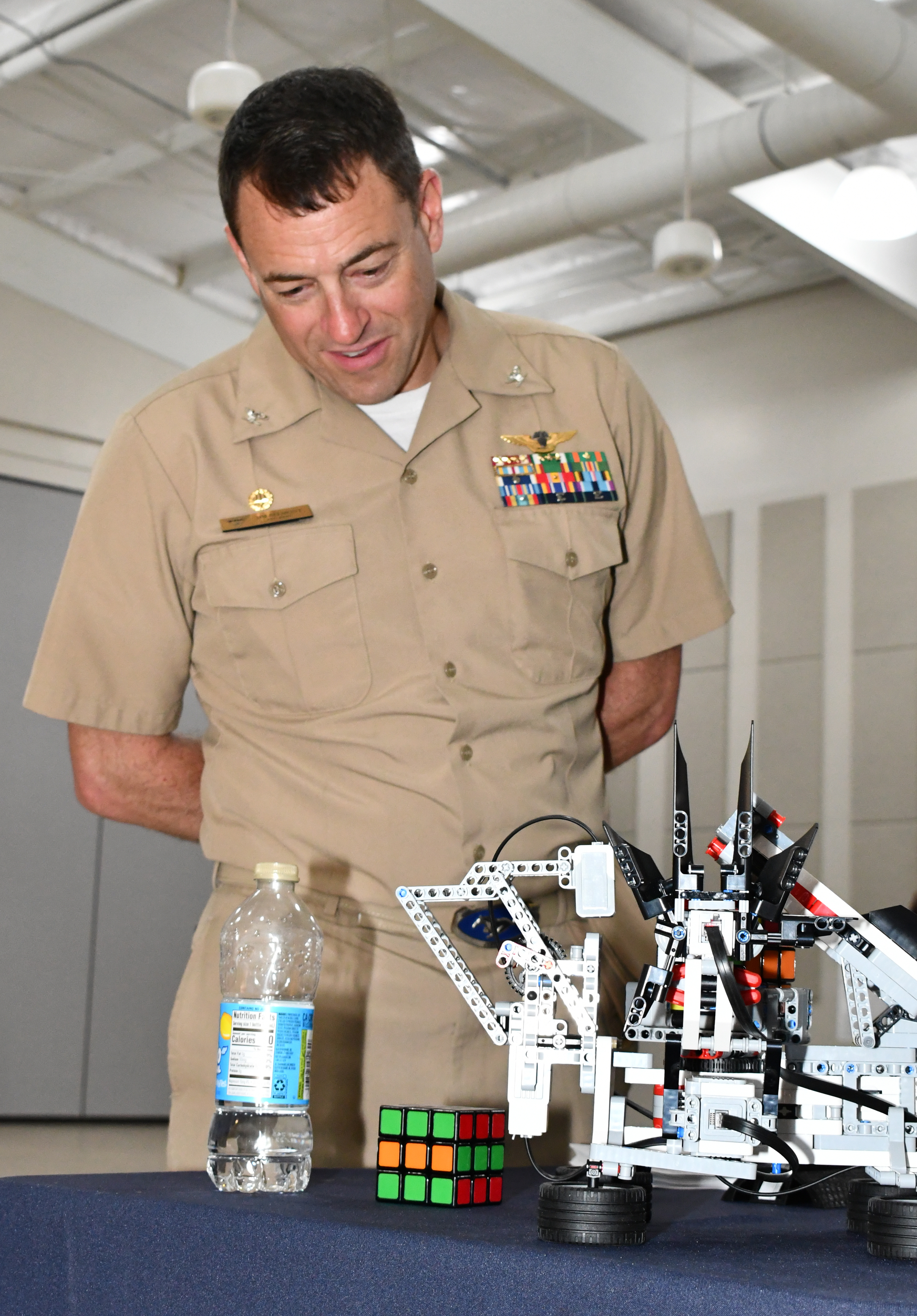 Military officer watches puzzle cube-solving robot