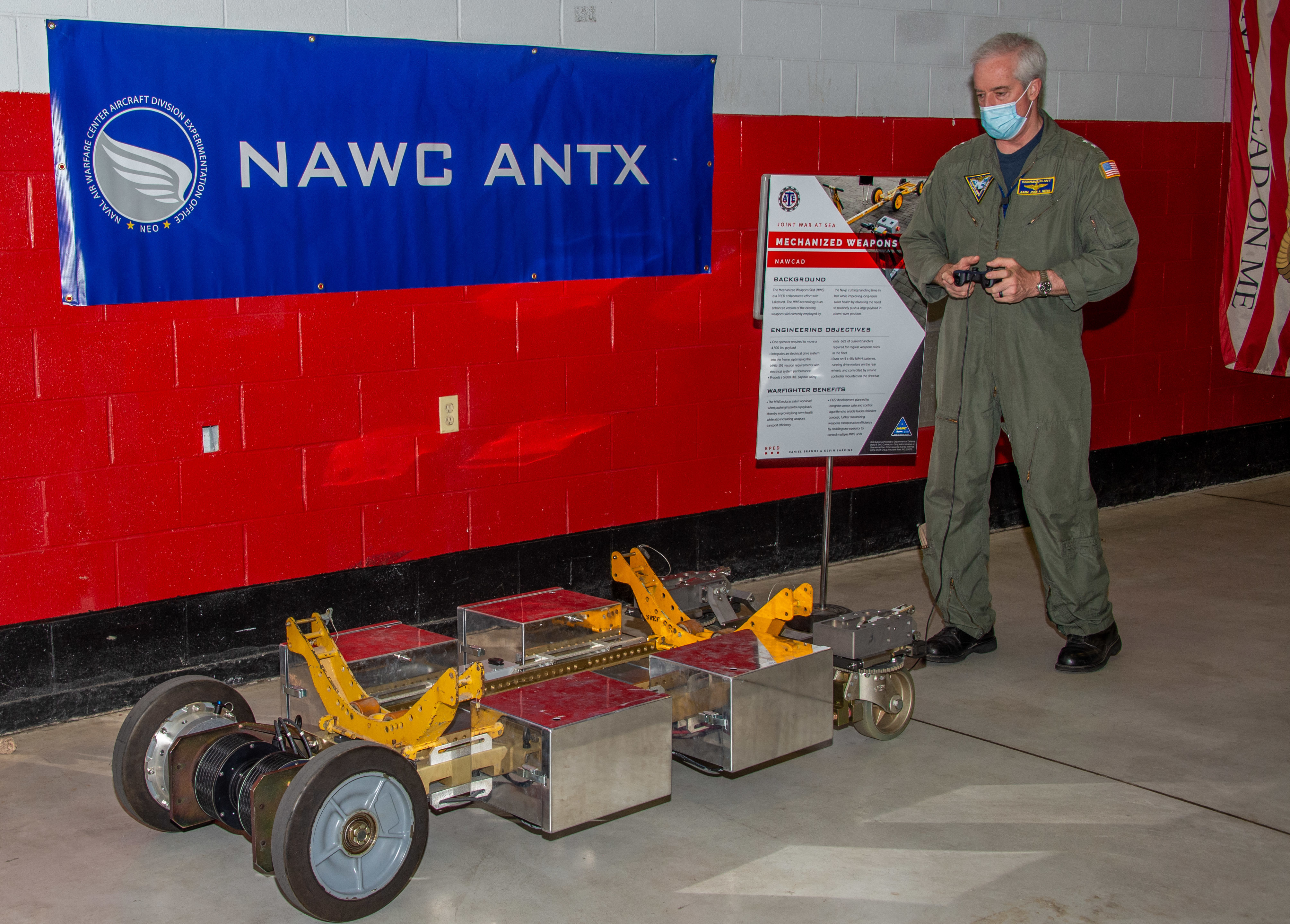 Naval Air Force Atlantic Commander, Rear Adm. John F. Meier, parks a mechanized weapons skid developed by the Naval Air Warfare Center Aircraft Division during its third annual Advanced Naval Technology Exercise at indoor site at Lakehurst, New Jersey..