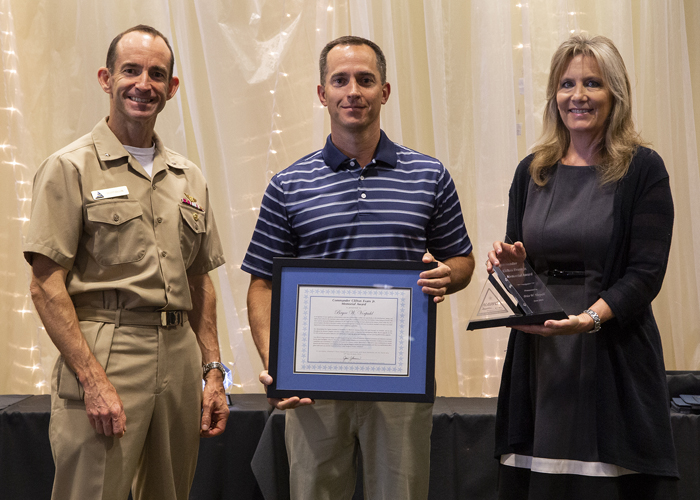 Bryce Vorpahl accepts the Cmdr. Clifton Evans Jr. Memorial Award from Rear Adm. Scott Dillon, NAWCWD commander, and Joan Johnson, NAWCWD executive director, during the 2019 Honorary Awards Ceremony at China Lake on June 25. (U.S. Navy photo by Ryan Smith)