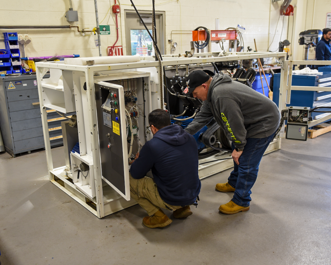 Team members work on a piece of cryogenic equipment at NAWCAD Lakehurst
