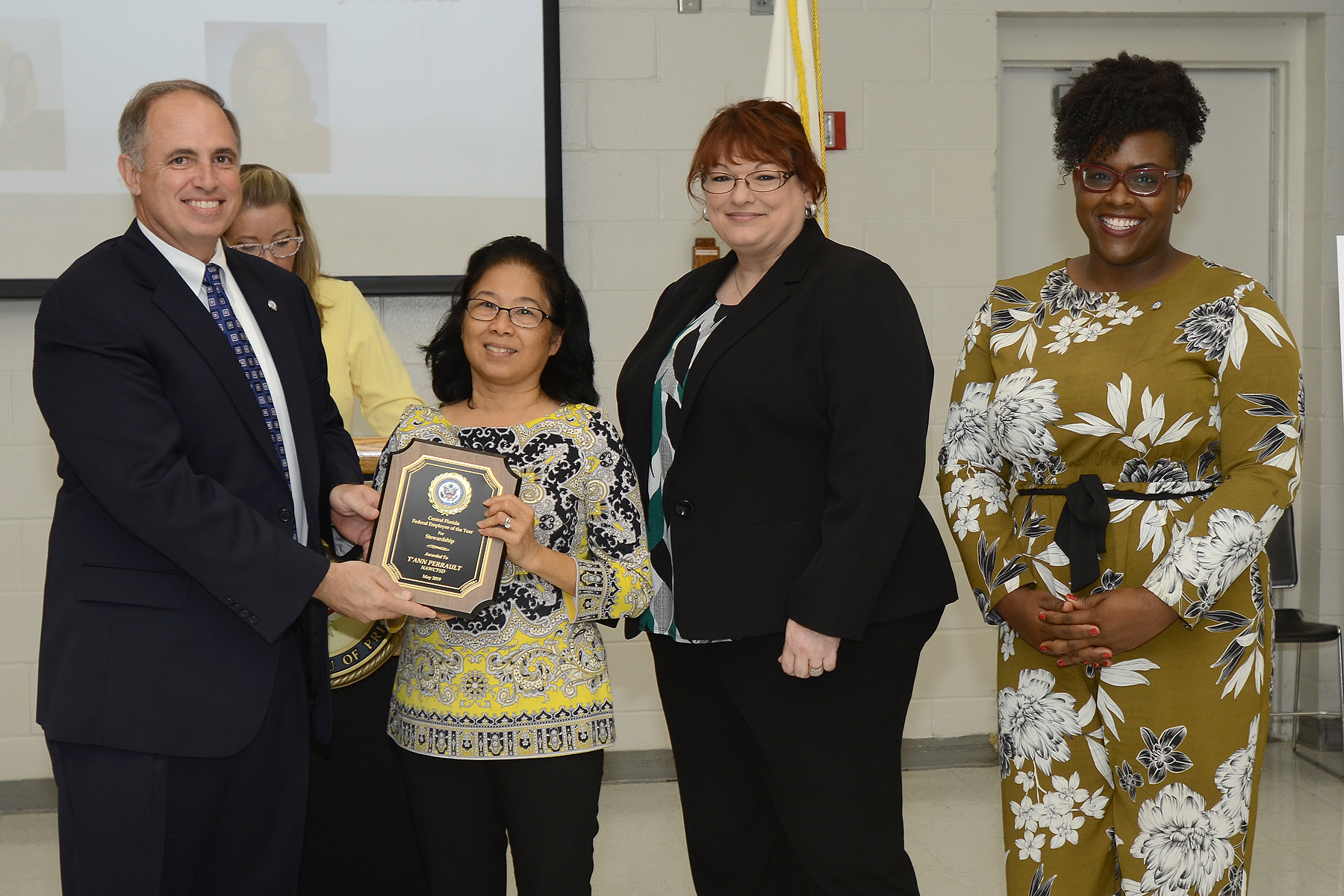WILDWOOD, Fla. (May 10, 2019) John J. Daly, President of the Central Florida Federal Executive Association presents Mong Trang "T'Ann" Perrault from the NAWCTSD Contracting Office with the association's Federal Employee of the Year Award for Stewardship. The awards ceremony held during Public Service Recognition Week honored the contributions of federal employees throughout Central Florida.  
