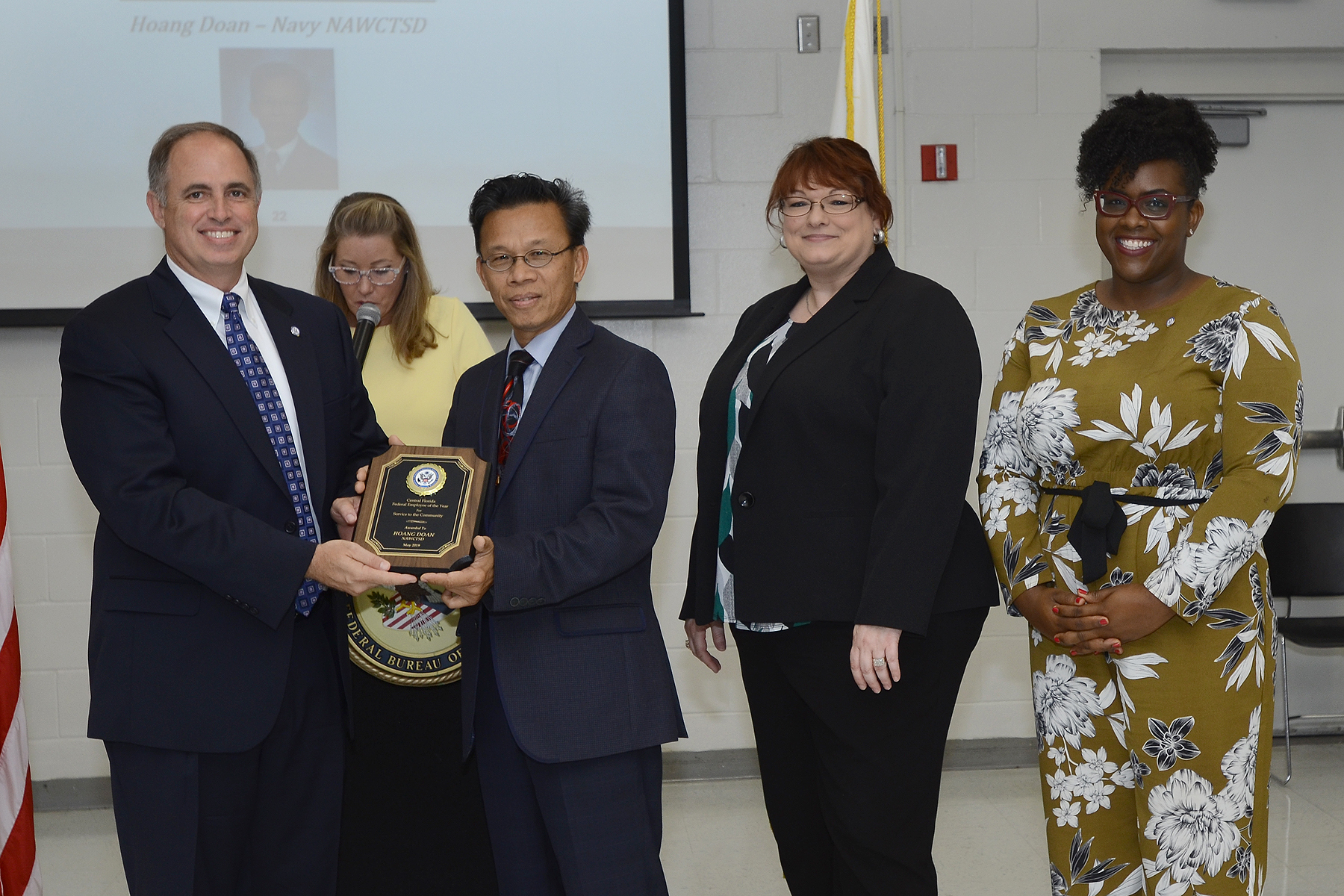 John J. Daly, President of the Central Florida Federal Executive Association presents Hoang "HD" Doan (NAWCTSD 4.6.8.5) with the association's Federal Employee of the Year Award for Service to the Community. The awards ceremony held during Public Service Recognition Week honored the contributions of federal employees throughout Central Florida.  