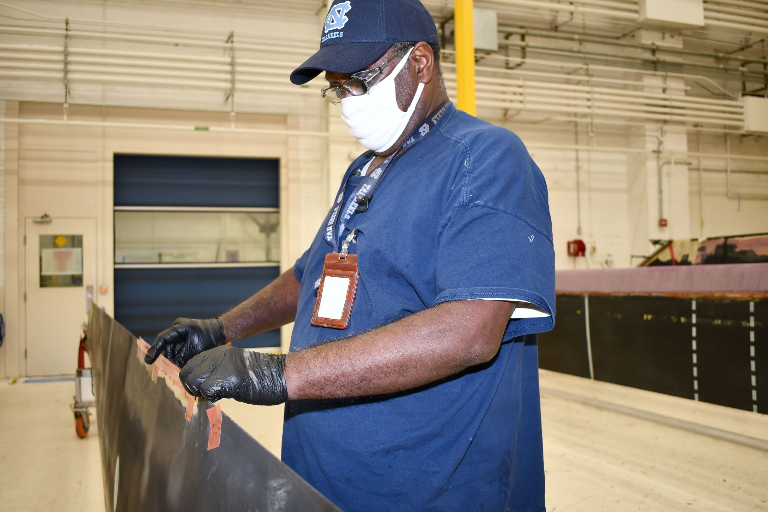 Man repairs H-53 helicopter main rotor blade