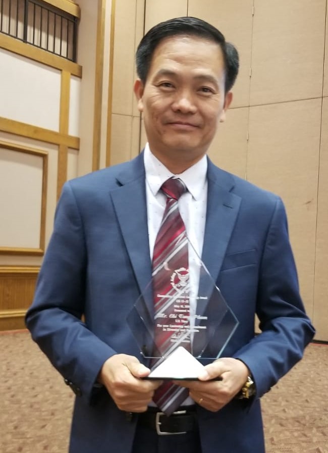 Pham holds award.