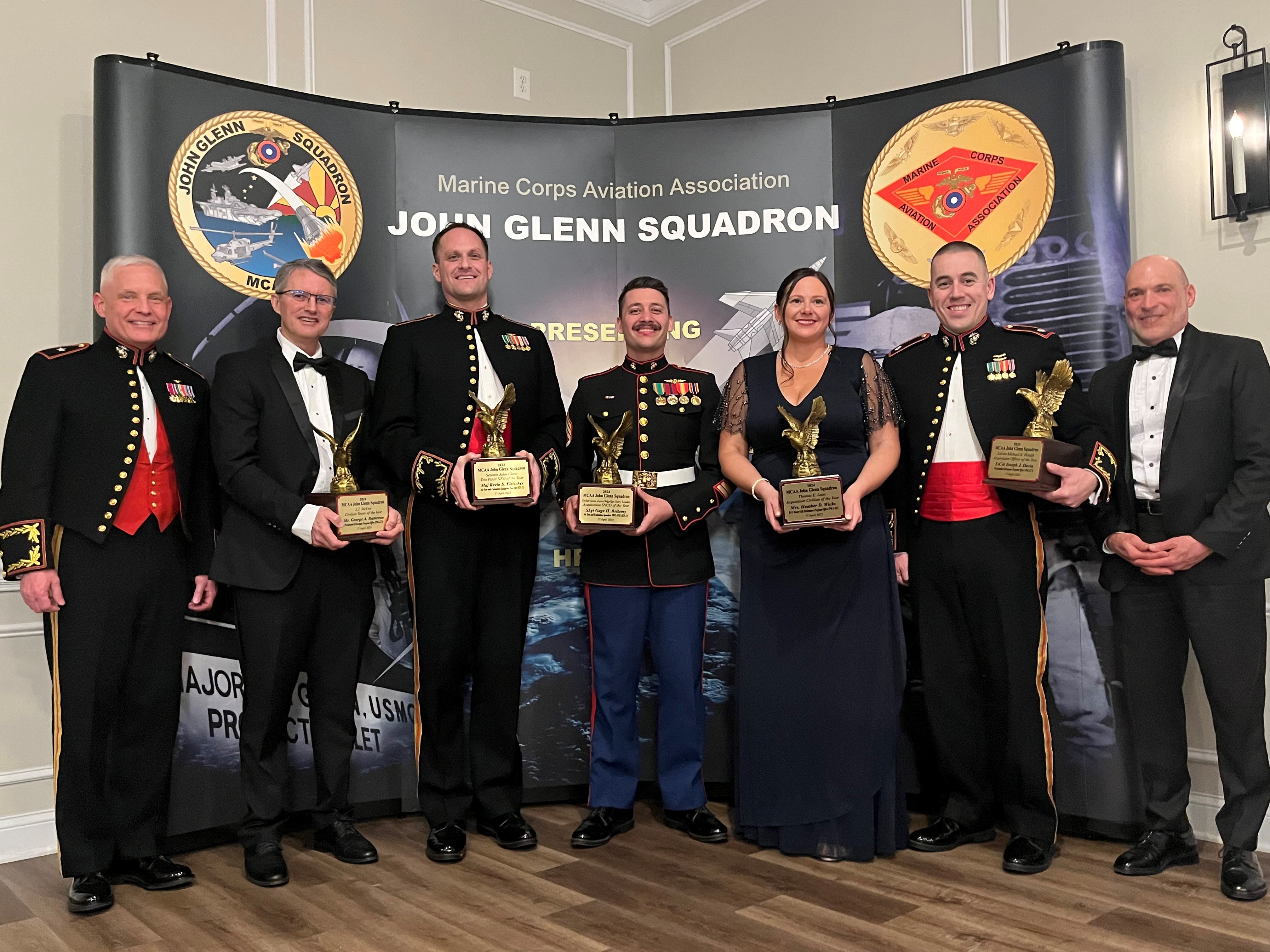 Group of Seven People with Awards in front of a Banner that Reads John Glenn Squadron