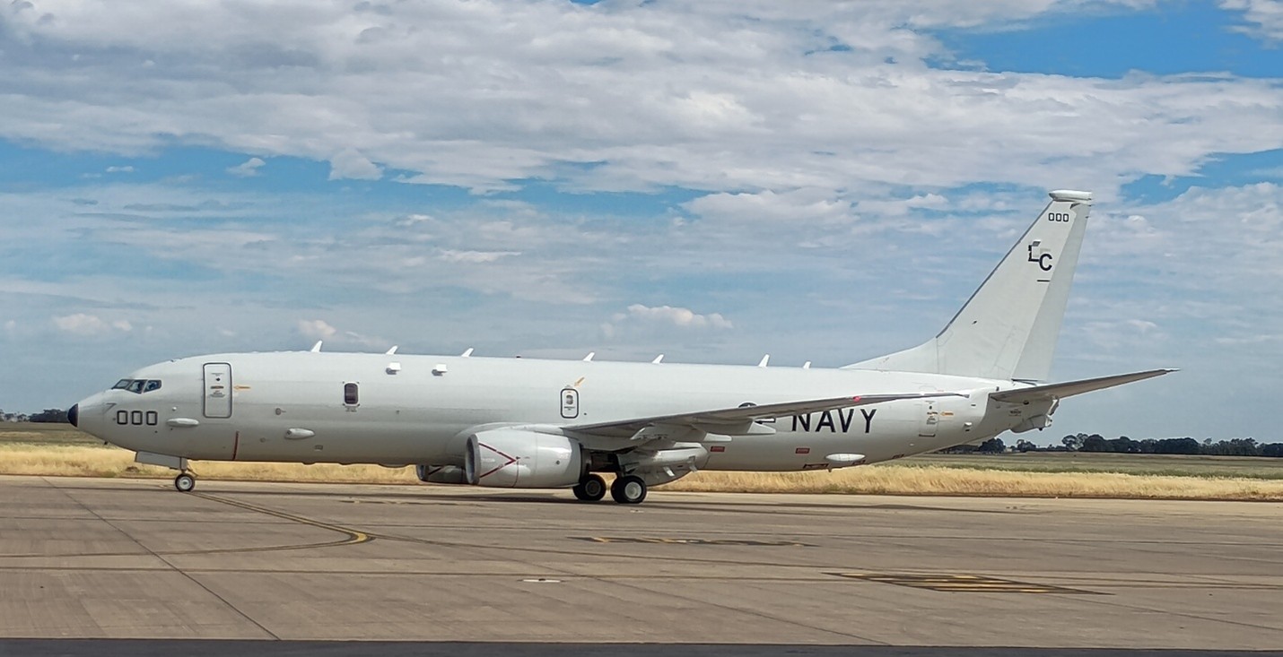 Plane on tarmac with blue skies and clouds