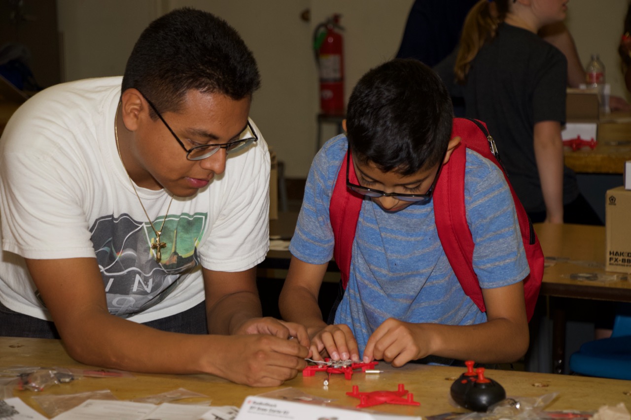 Kenn Hernandez, an electrical engineer at Naval Air Warfare Center Weapons Division, helps a student build a drone during a four-day coding camp in Ridgecrest, California on June 3-6. (U.S. Navy photo by Paul Kakert)