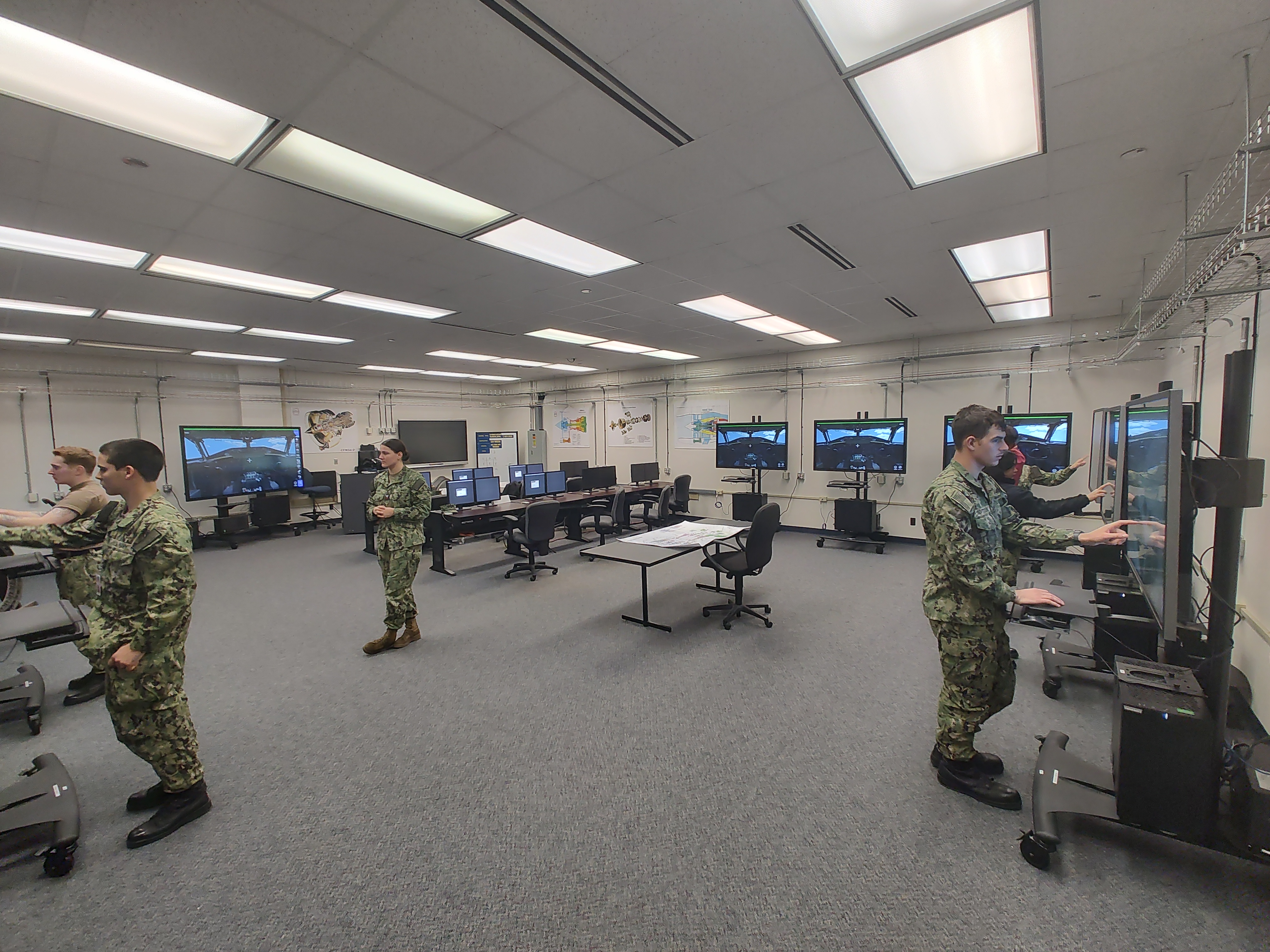 Sailors in a classroom training conducting training using virtual touch-screens