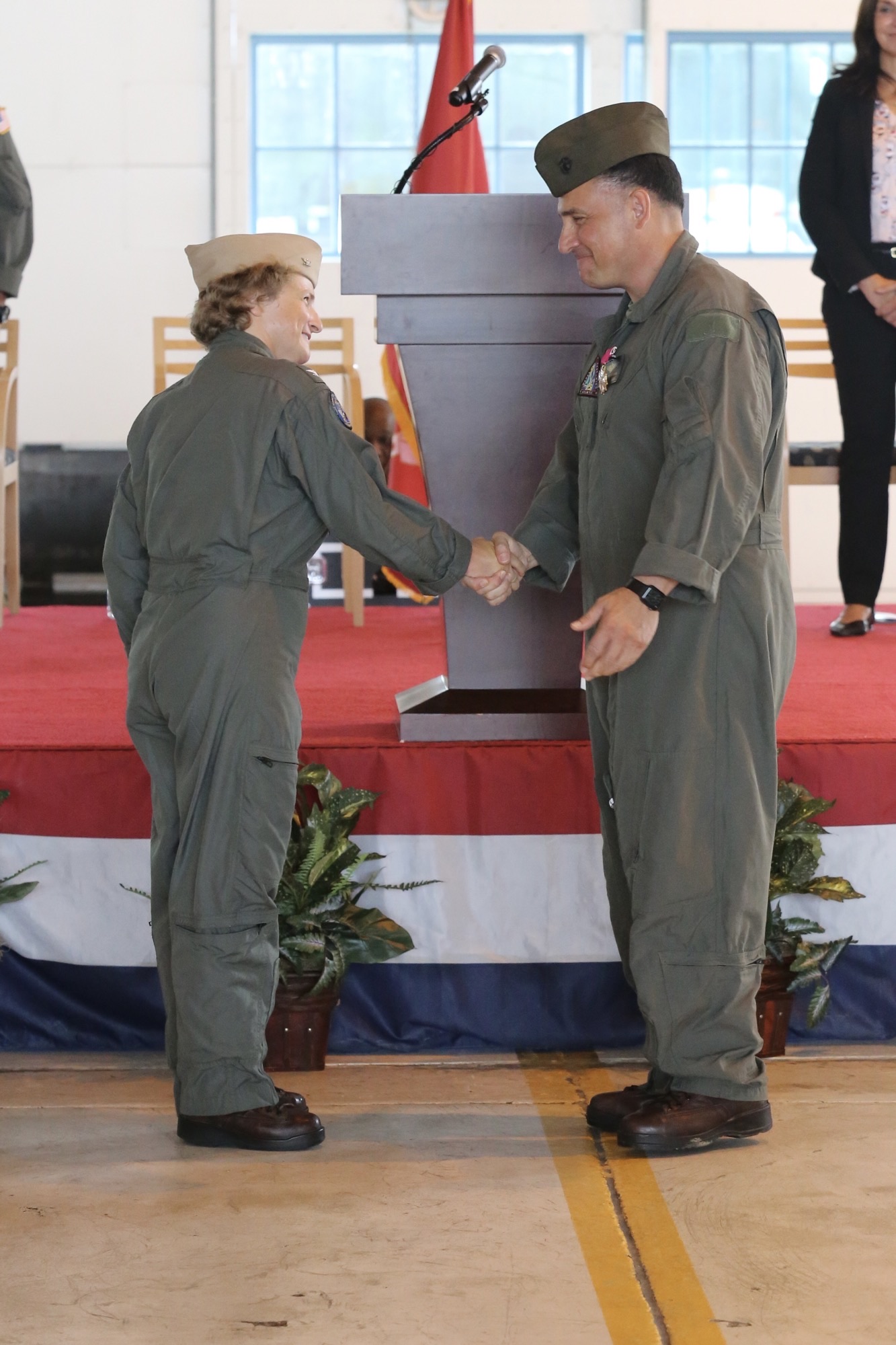 Capt. Elizabeth Somerville shakes hands with Col. Richard Marigliano in front of the podium during a change of command ceremony.