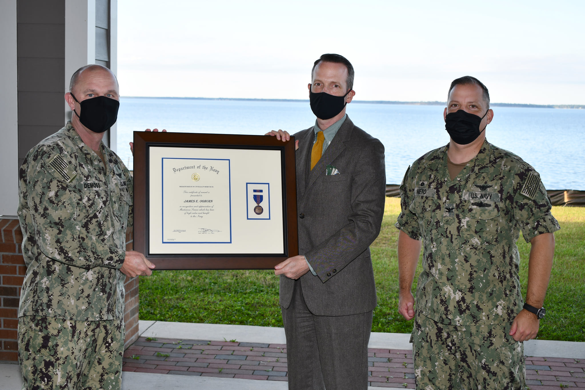 Three men pose for award presentation photo
