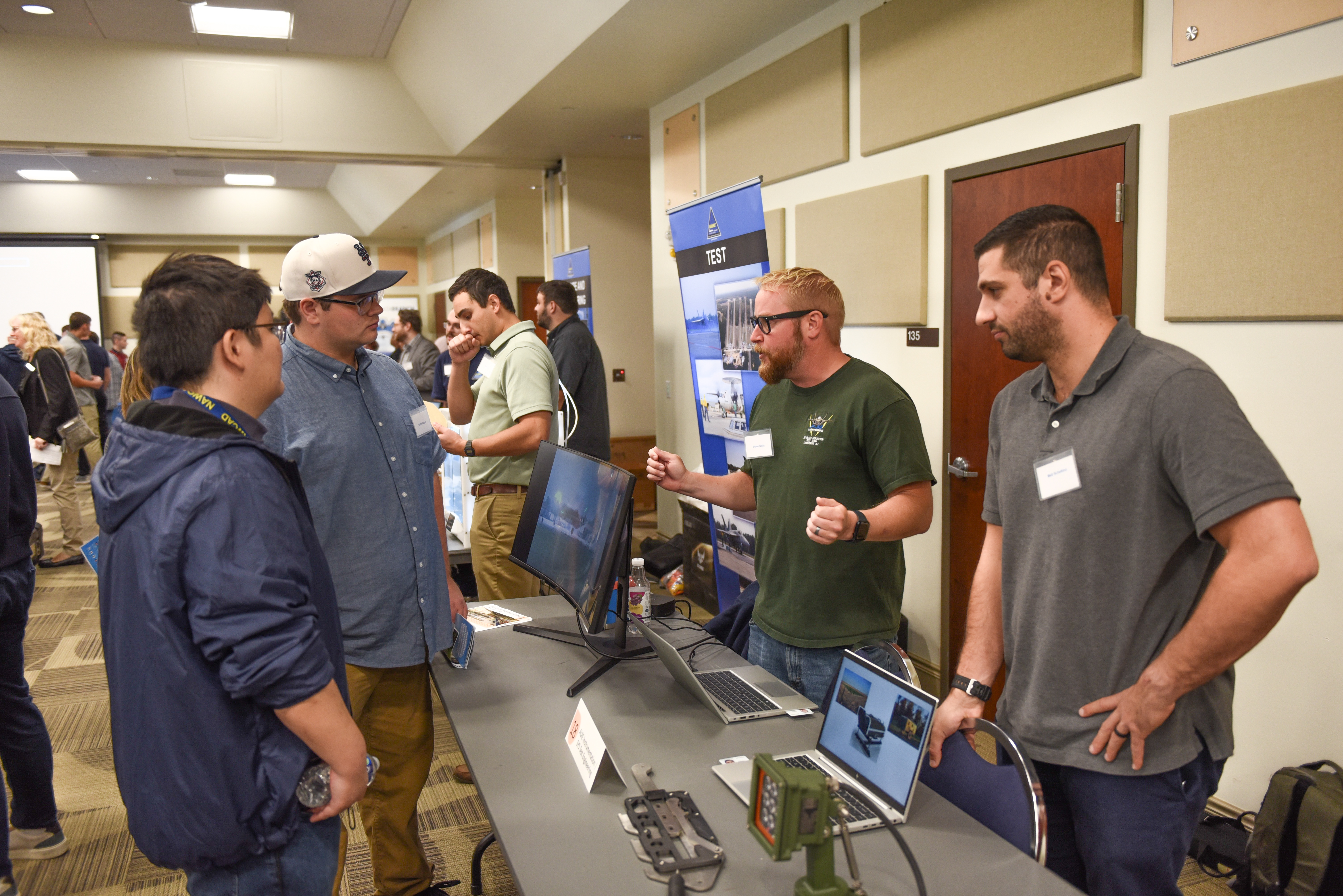 Participants visit one of the tables at Naval Air Warfare Center Aircraft Division Lakehurst's Open House