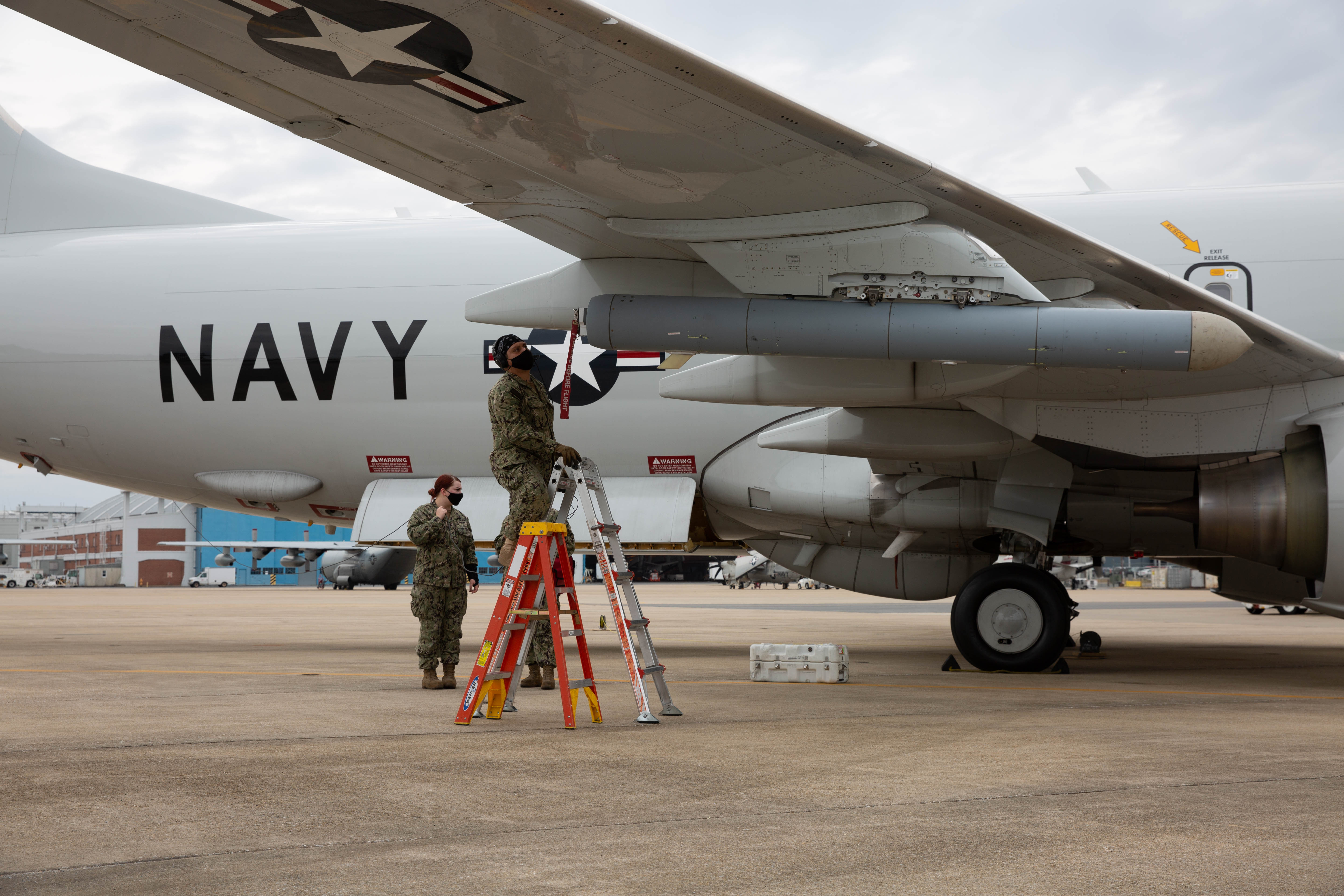 A member of VX-20 puts a radio frequency countermeasure on a P-8A Poseidon. 