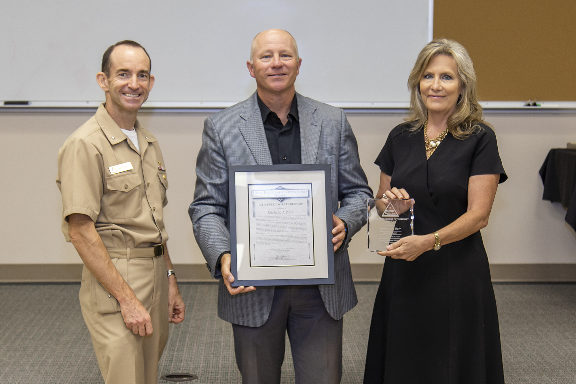 Rear Adm. Scott Dillon, left, NAWCWD commander, and Joan Johnson, right, NAWCWD executive director, pose with EEO Supervisor Award winner Rich Burr during the Honorary Awards Ceremony in Point Mugu, California, on June 27. (U.S. Navy photo by Rob Grabendike)