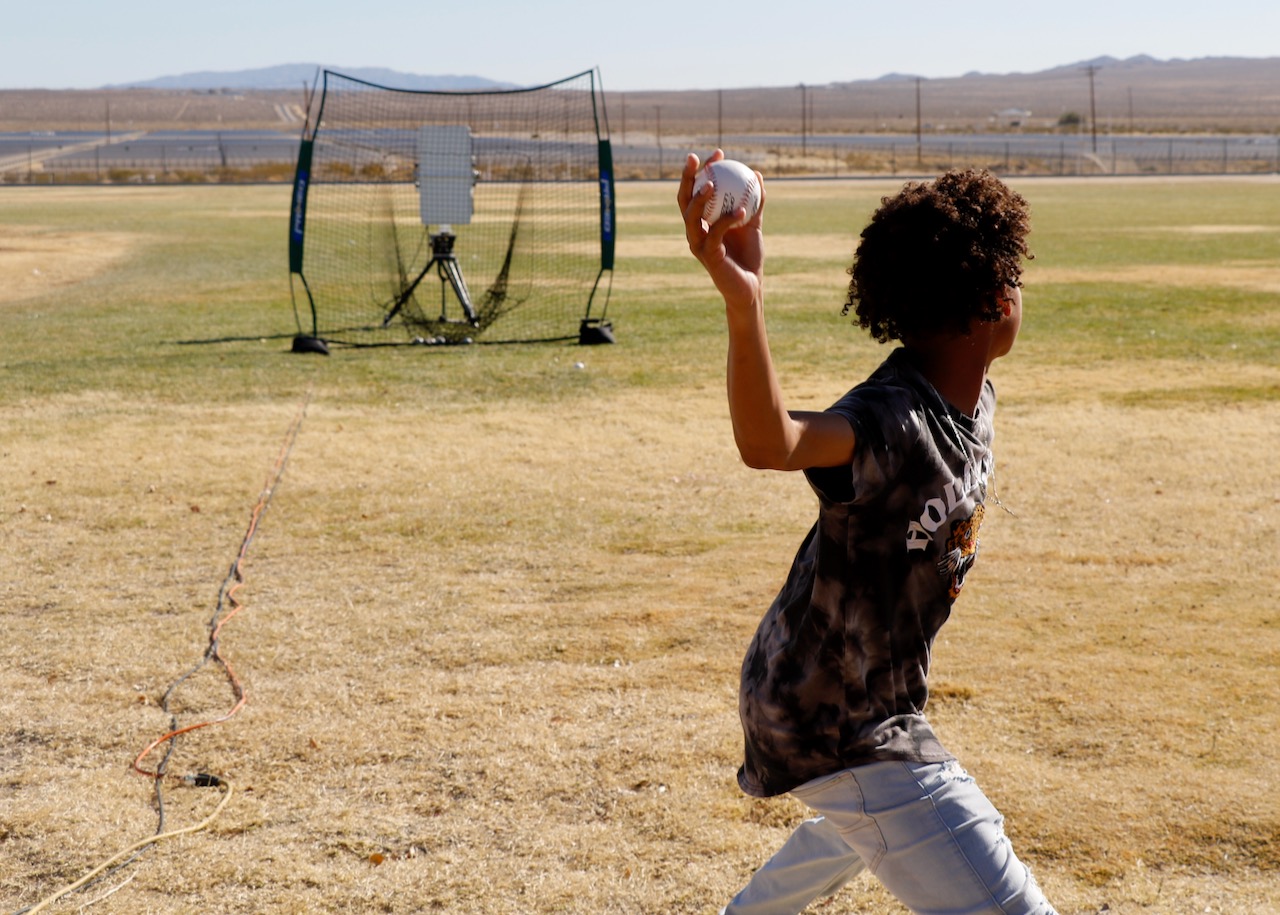 A Burroughs High School student winds up to throw a pitch so that the radar can measure its speed during the BHS STEM day Nov. 8. (U.S. Navy photo by Paul Kakert)