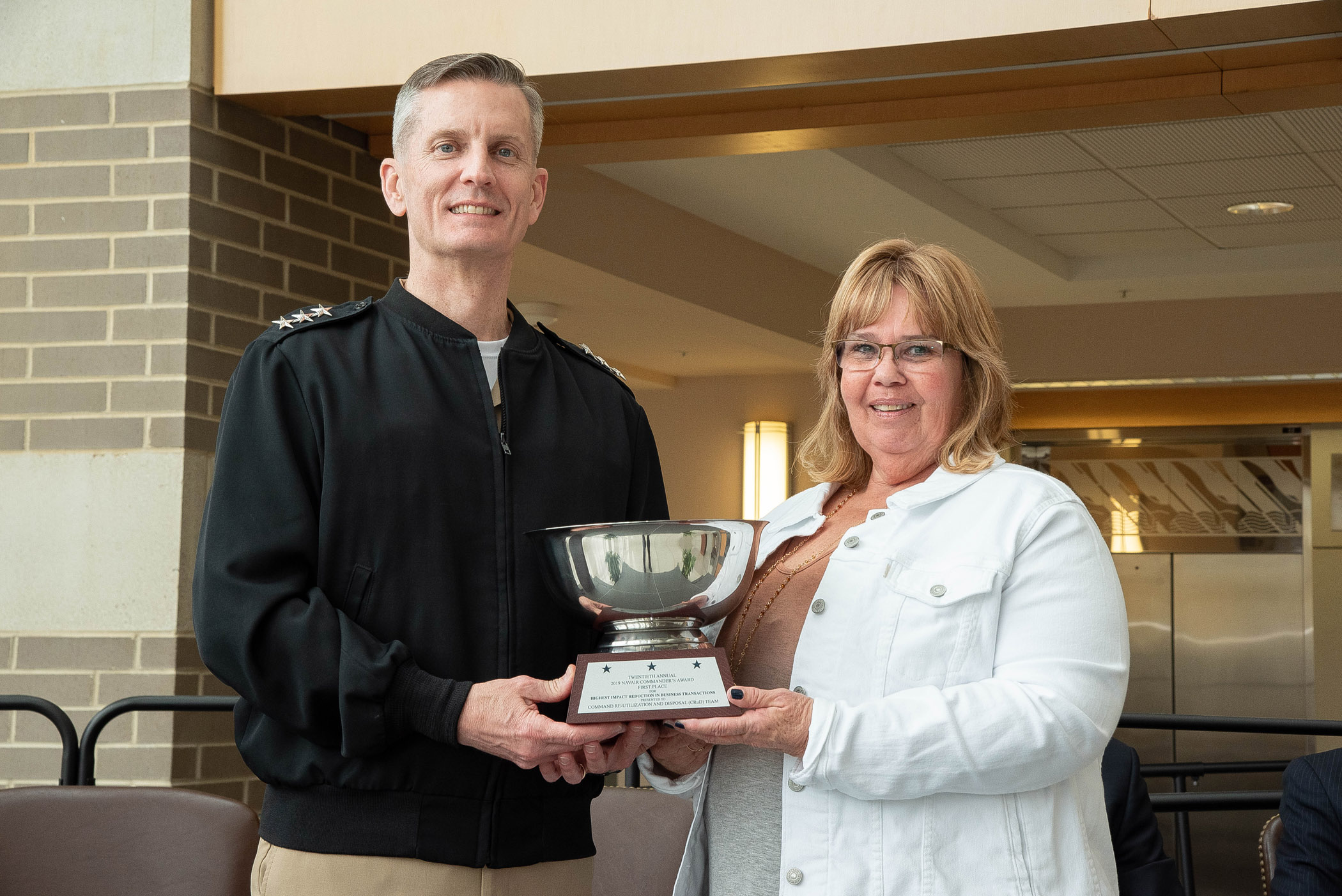 Command Re-utilization and Disposal team lead Michele Maples accepts the NAVAIR Commander’s Award for Highest Impact Reduction in Business Transactions from Vice Adm. Dean Peters, NAVAIR commander, during a ceremony March 10 at Naval Air Station Patuxent River. (U.S. Navy photo by Peter Fitzpatrick)