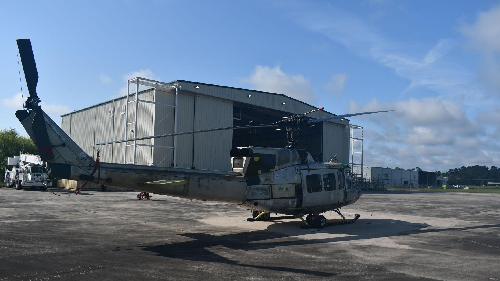 UH-1N "Huey" sits in front of aircraft hangar