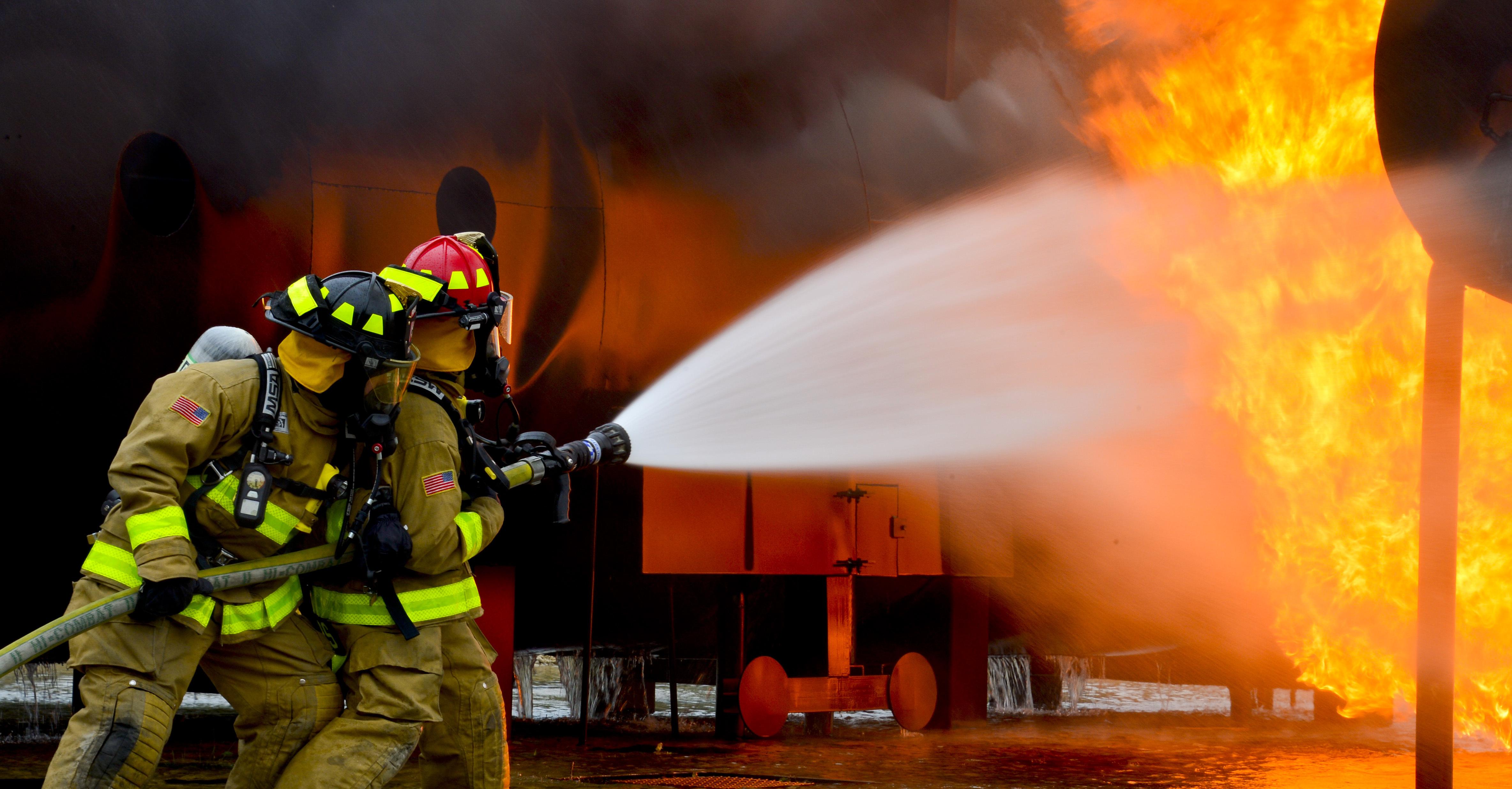 Firefighters from the 181st and the 317th Engineer Detachment spray water during an aircraft rescue and firefighting fire burn.