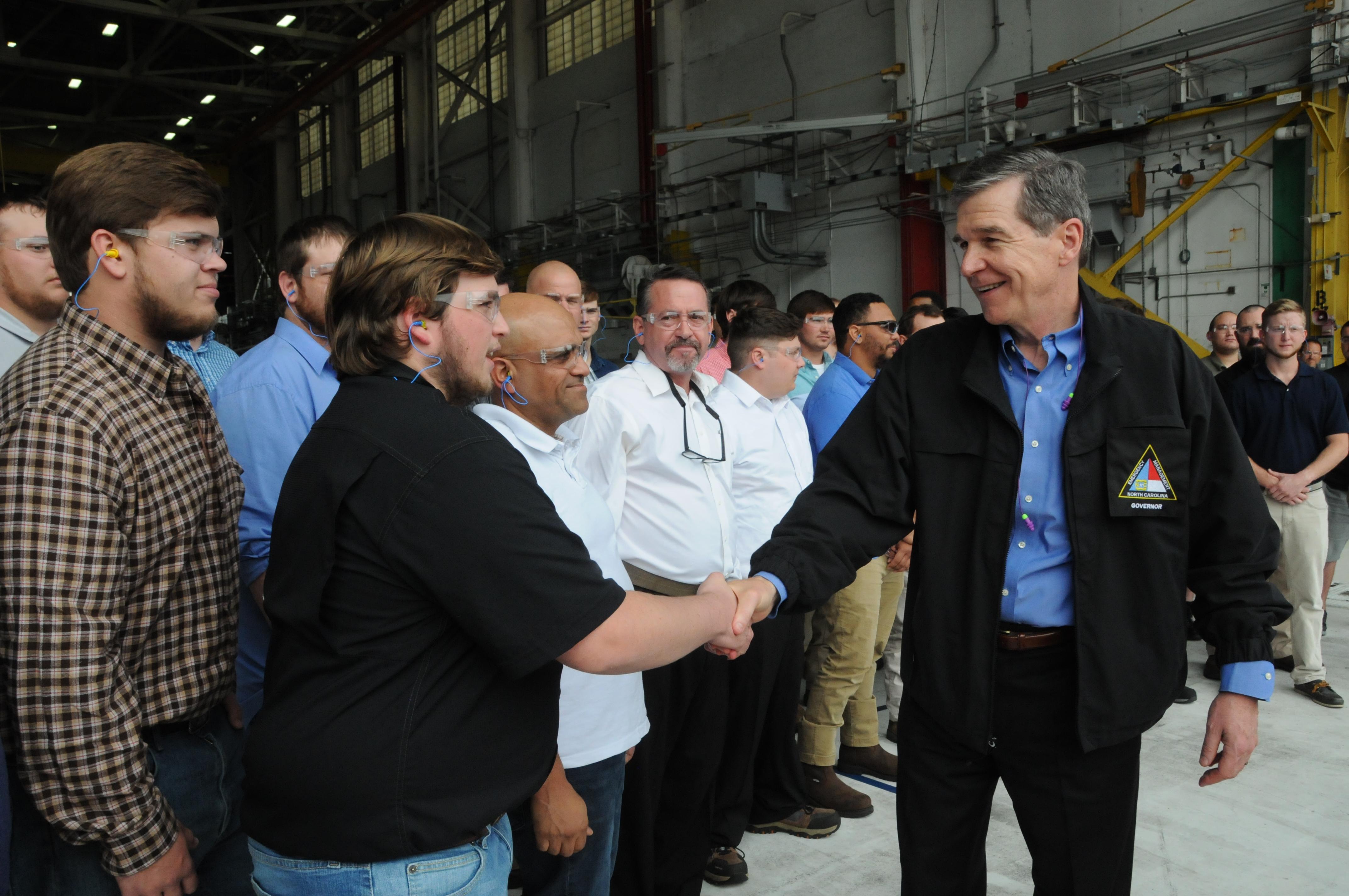 North Carolina Gov. Roy Cooper shakes hands with FRCE apprentices