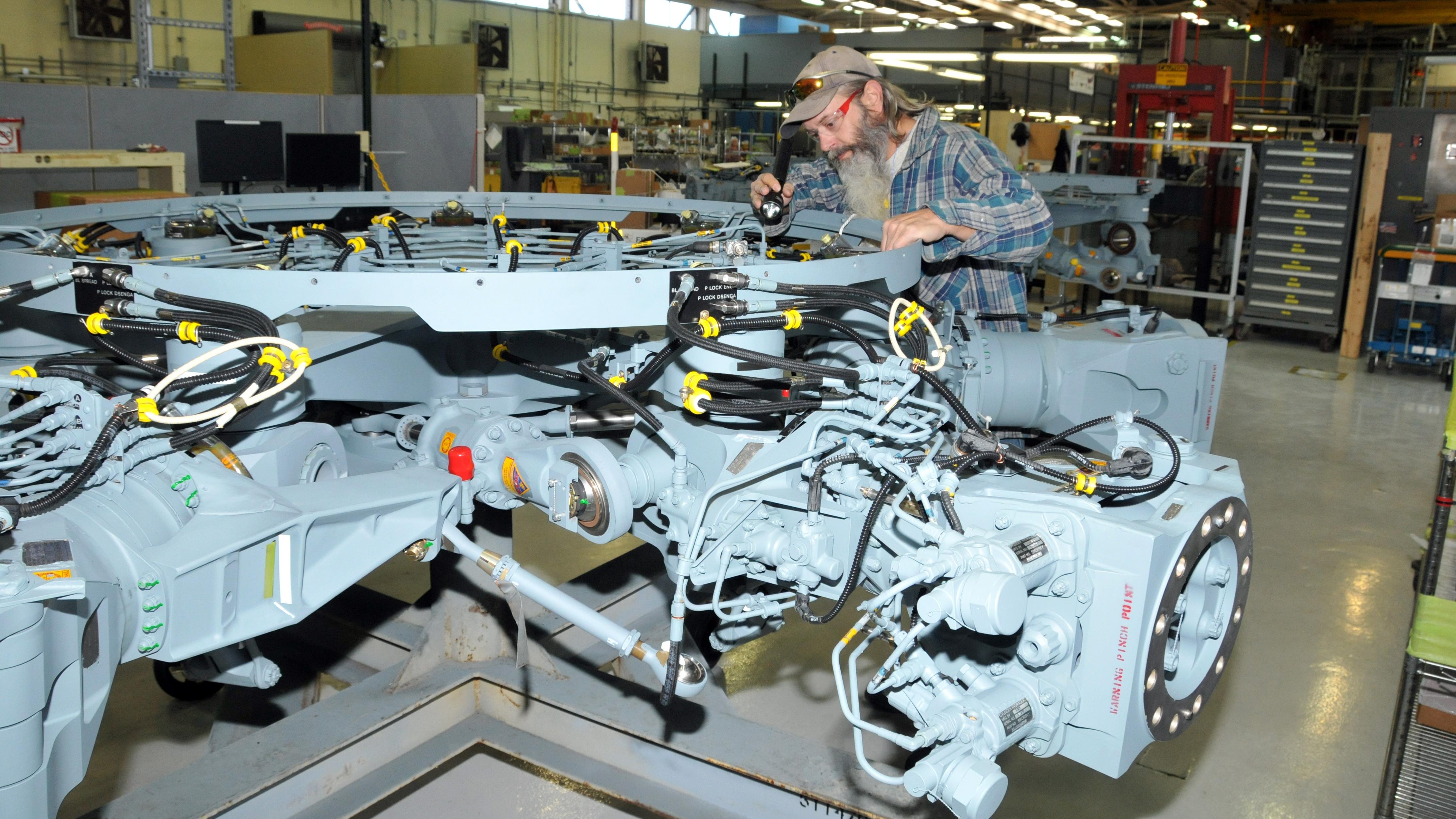 Aircraft mechanic inspects completed H-53 helicopter rotor head