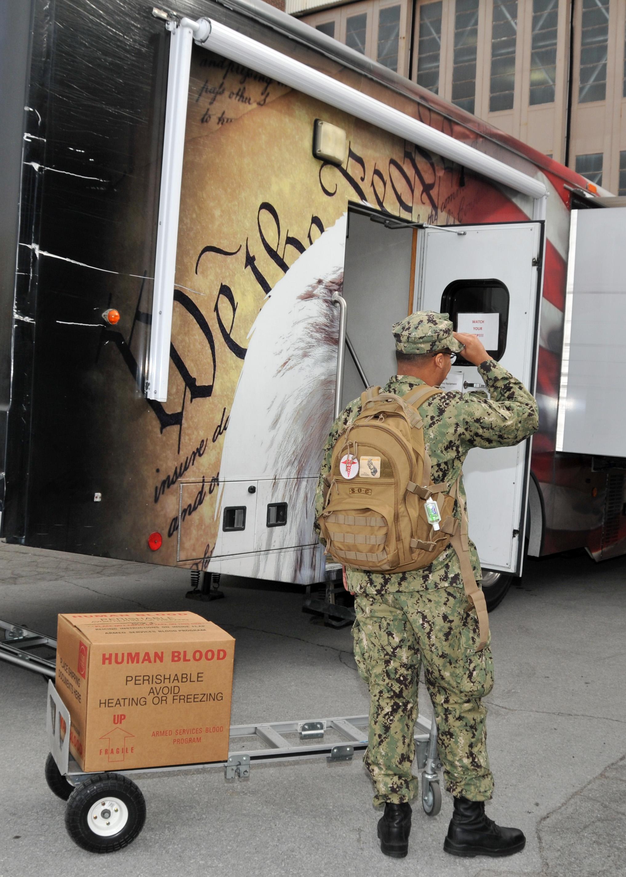 Sailor prepares to move box containing donate blood.