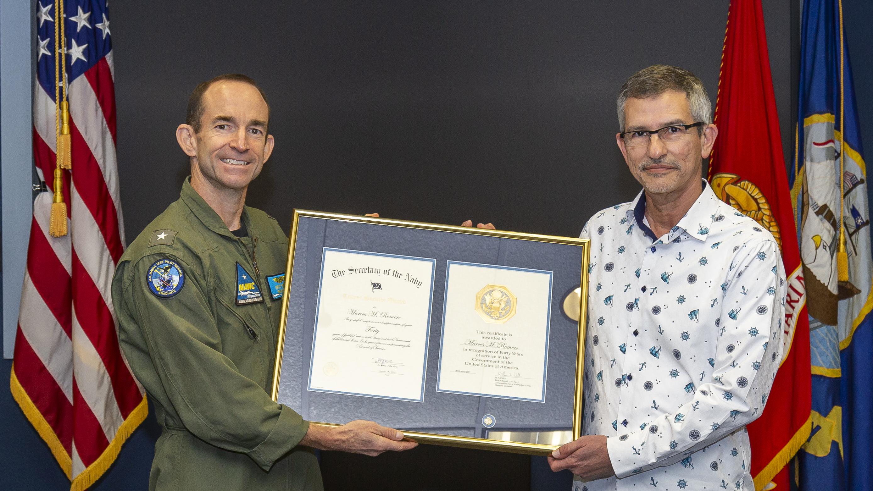 Rear Adm. Scott Dillon presents a 40-year length-of-service award to Marc Romero
