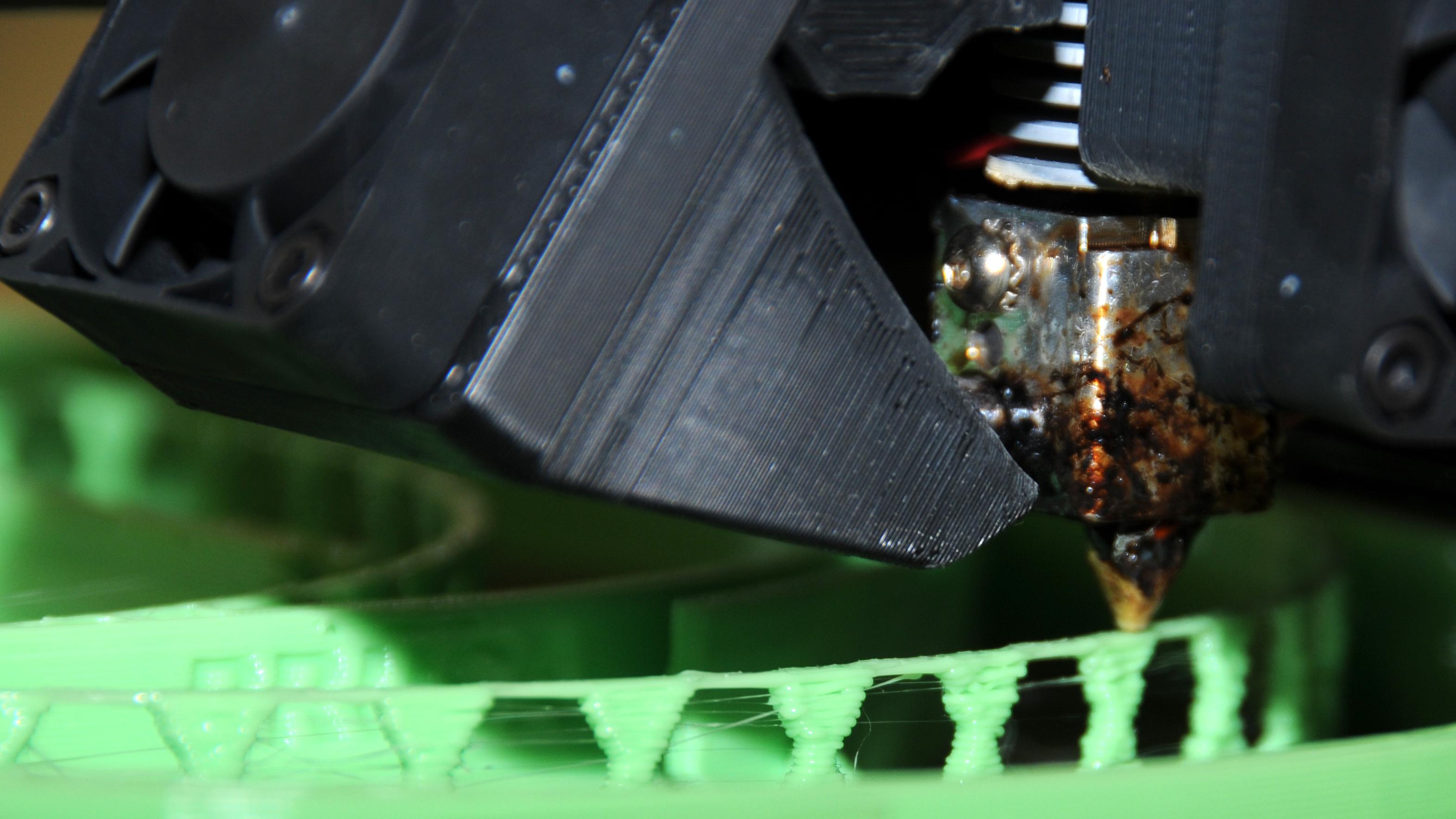 3D printer nozzle lays down layers of thermal plastic to produce a headband