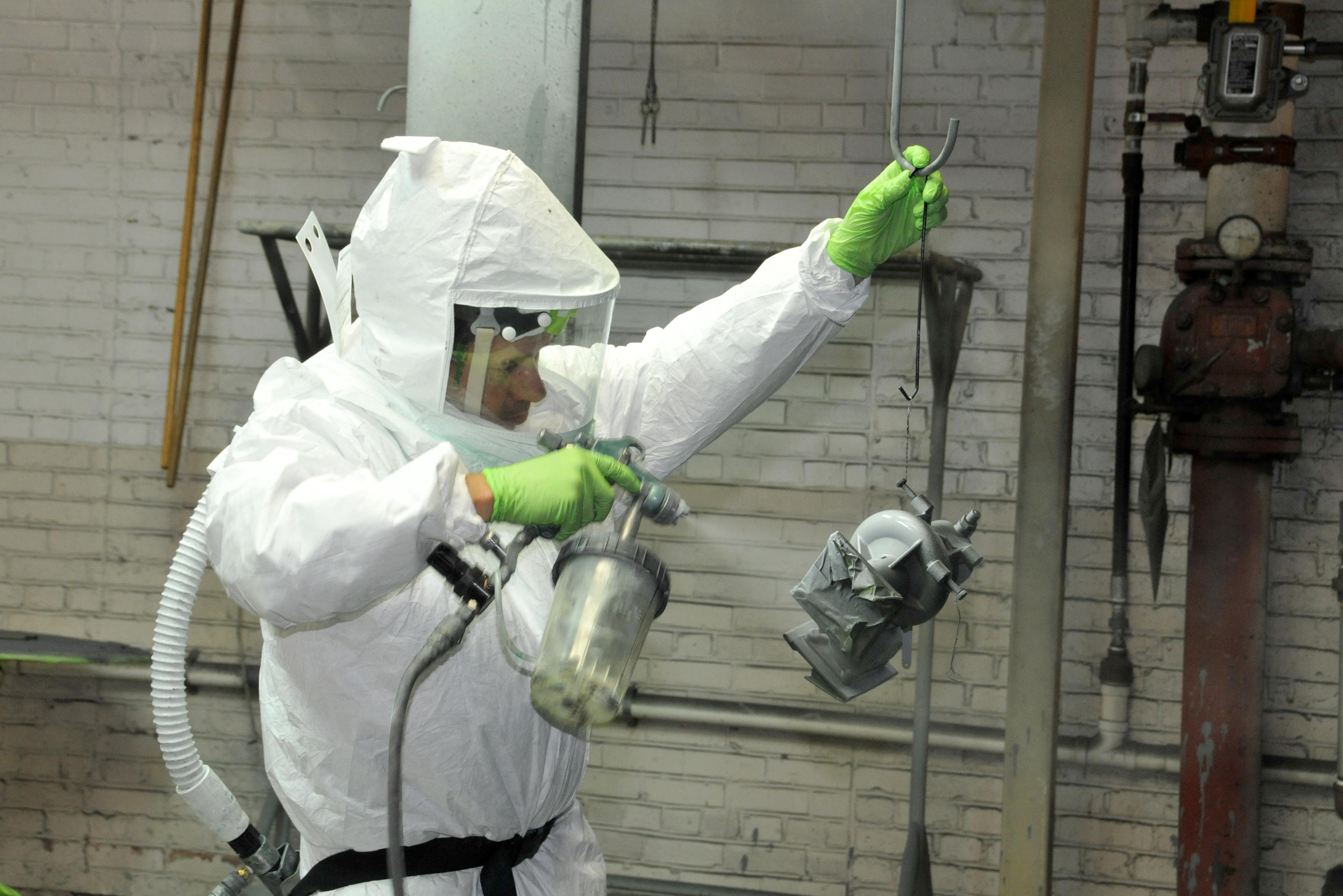 Painter primes a V-22 part to prepare it for painting.