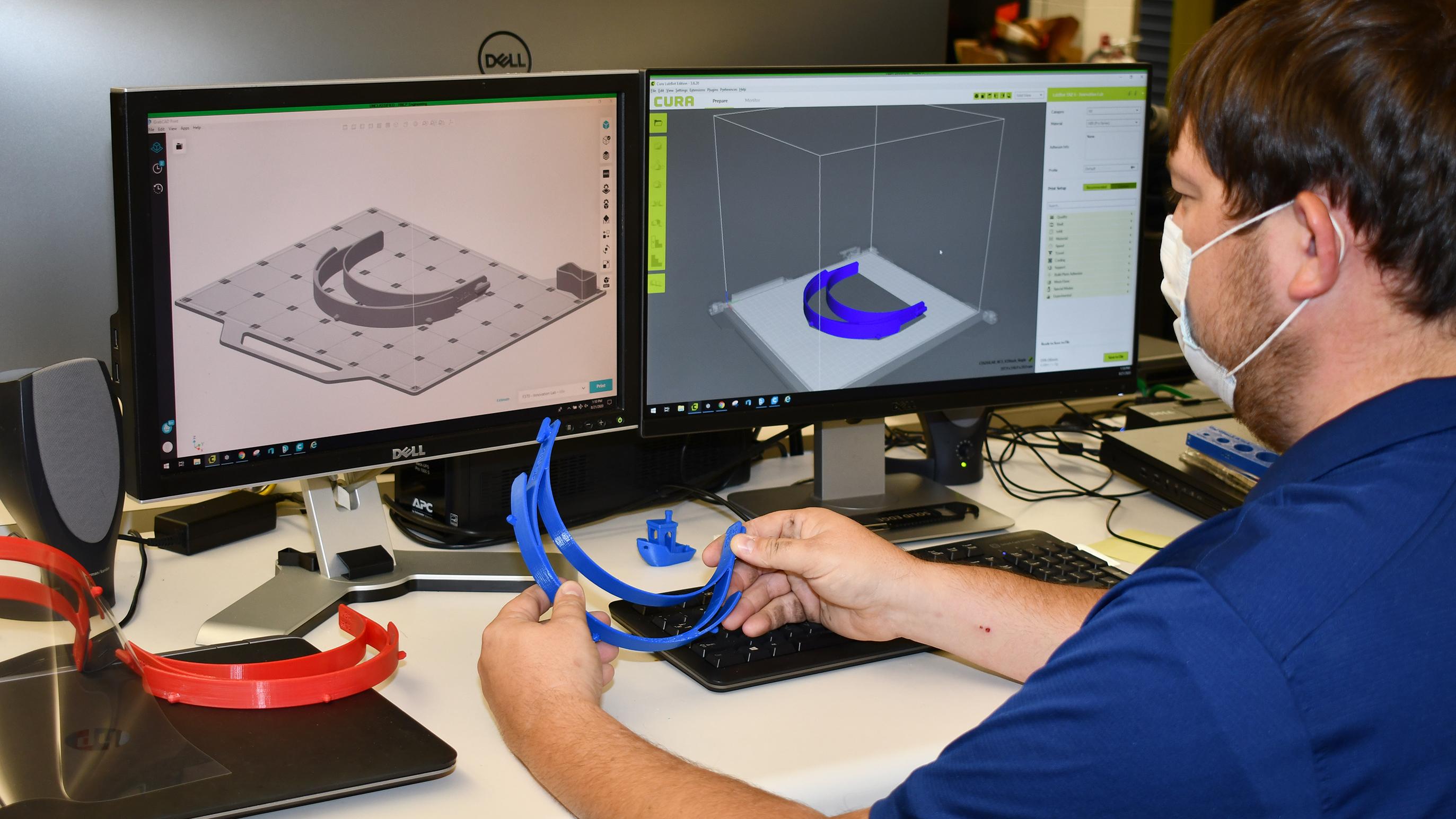 Man compares 3D-printed plastic headband to model on computer screen