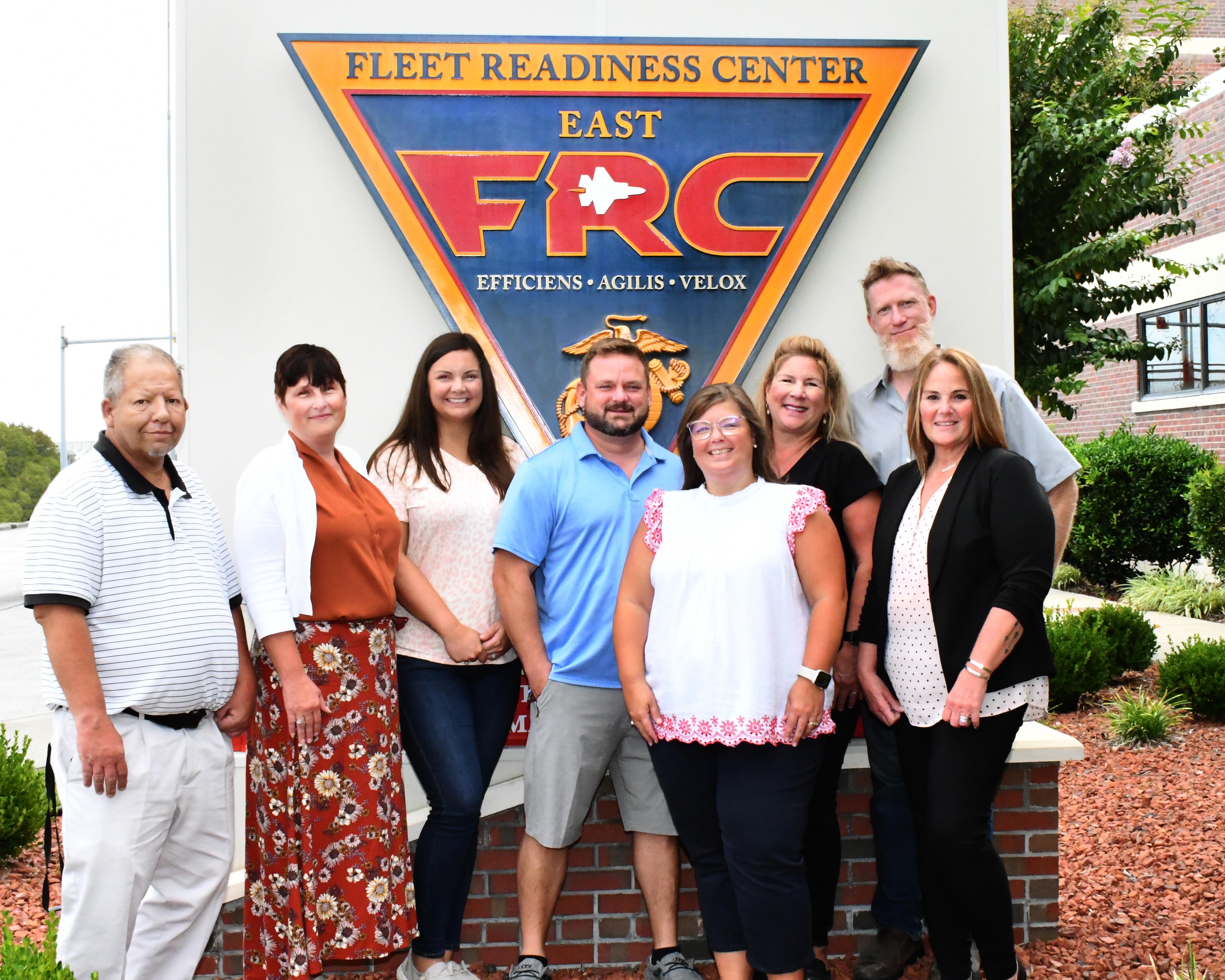 Group poses for photo in front of FRC East sign