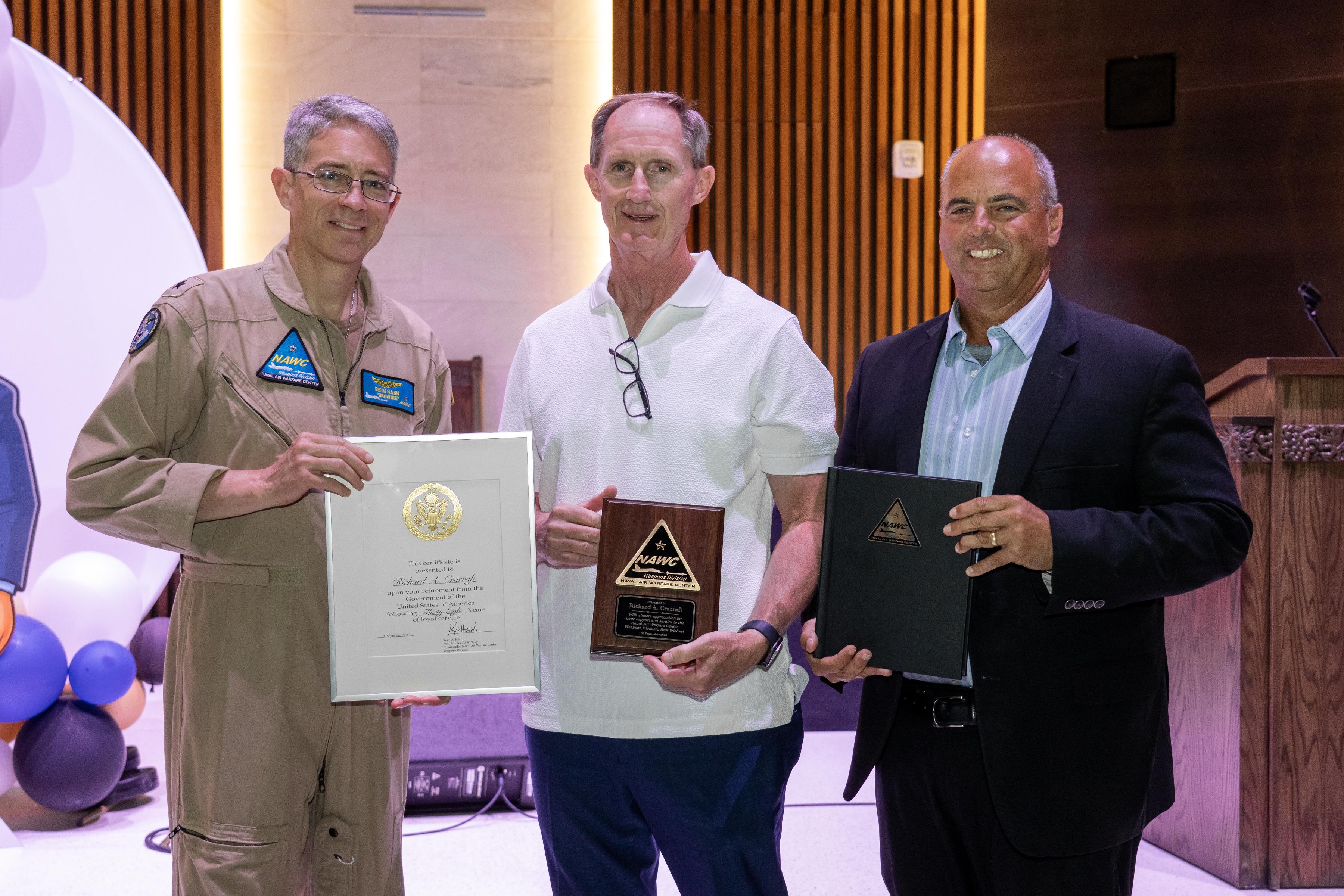 Naval Air Warfare Center Weapons Division Commander Rear Adm. Keith Hash (left) and Executive Director Dan Carreño honor Richard Cracraft for 38 years of service with the government during a retirement celebration July 10 in China Lake, Calif. Cracraft served as director of the Human Capital Management Group at NAWCWD for the past 23 years. 
