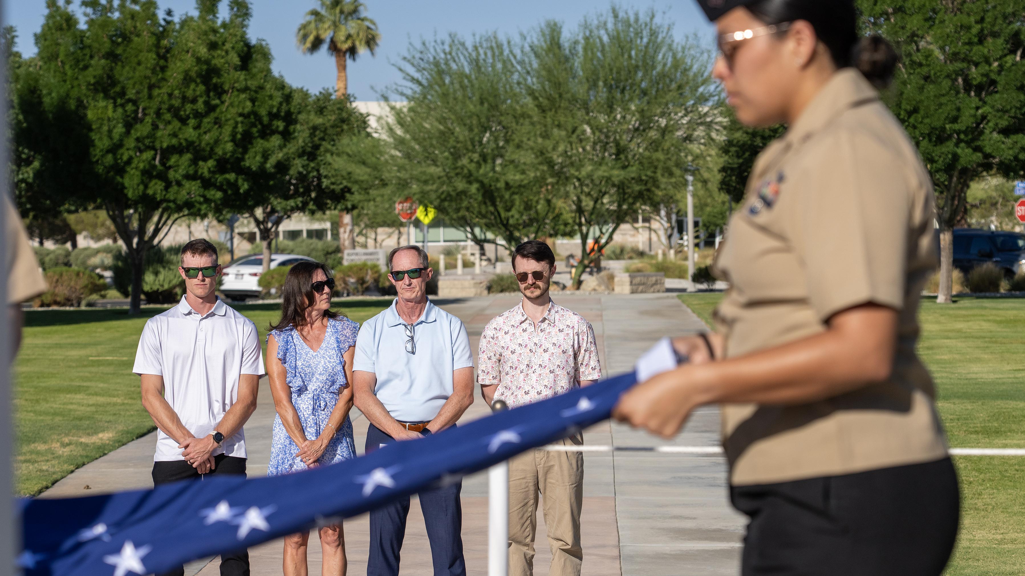Richard Cracraft (second from left), stands with his wife, Laurie, and their two sons, while being presented with a flag honoring his 38 years of federal service during a ceremony July 11 in China Lake, Calif. 