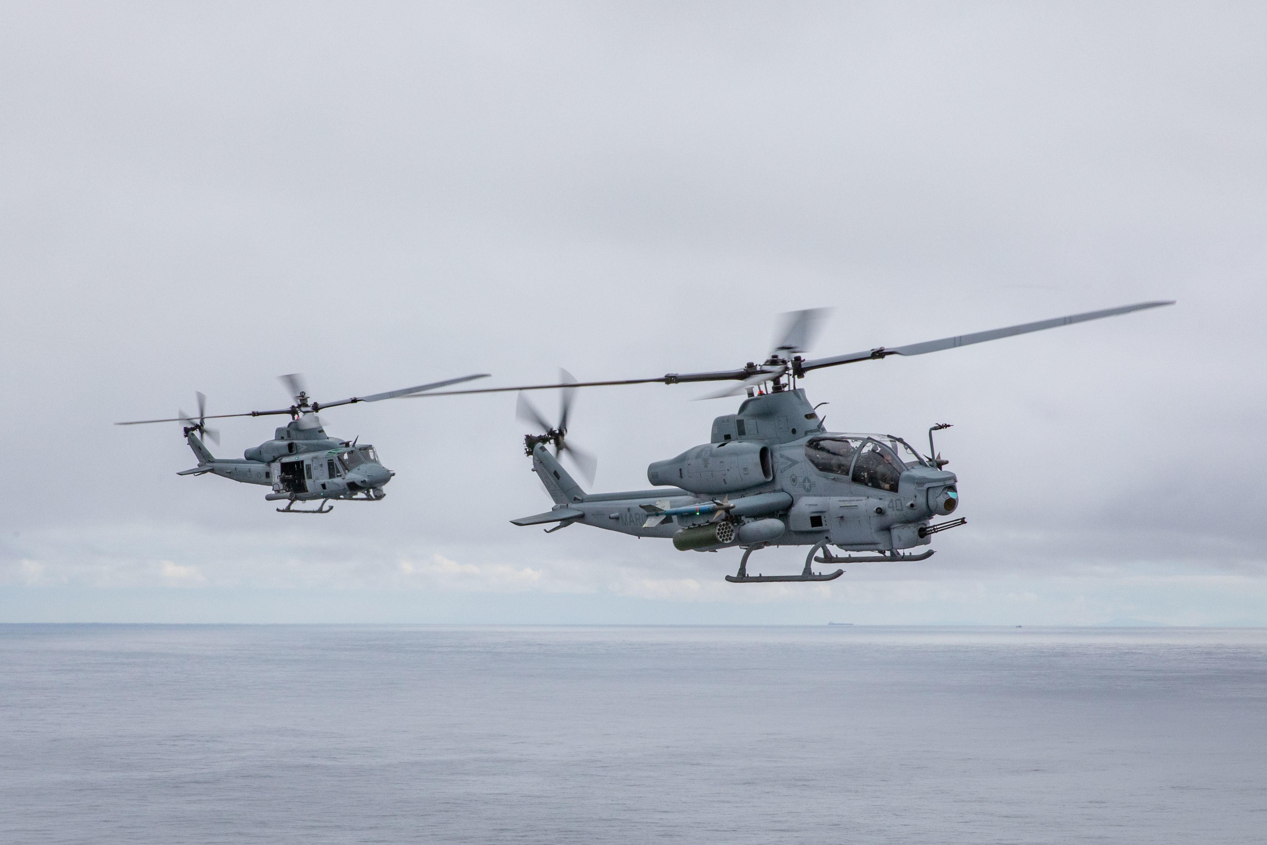 A UH-1Y Venom and AH-1Z Viper fly alongside the Wasp-class amphibious assault ship USS Iwo Jima (LHD 7) during a photo exercise, May 17, 2021. 